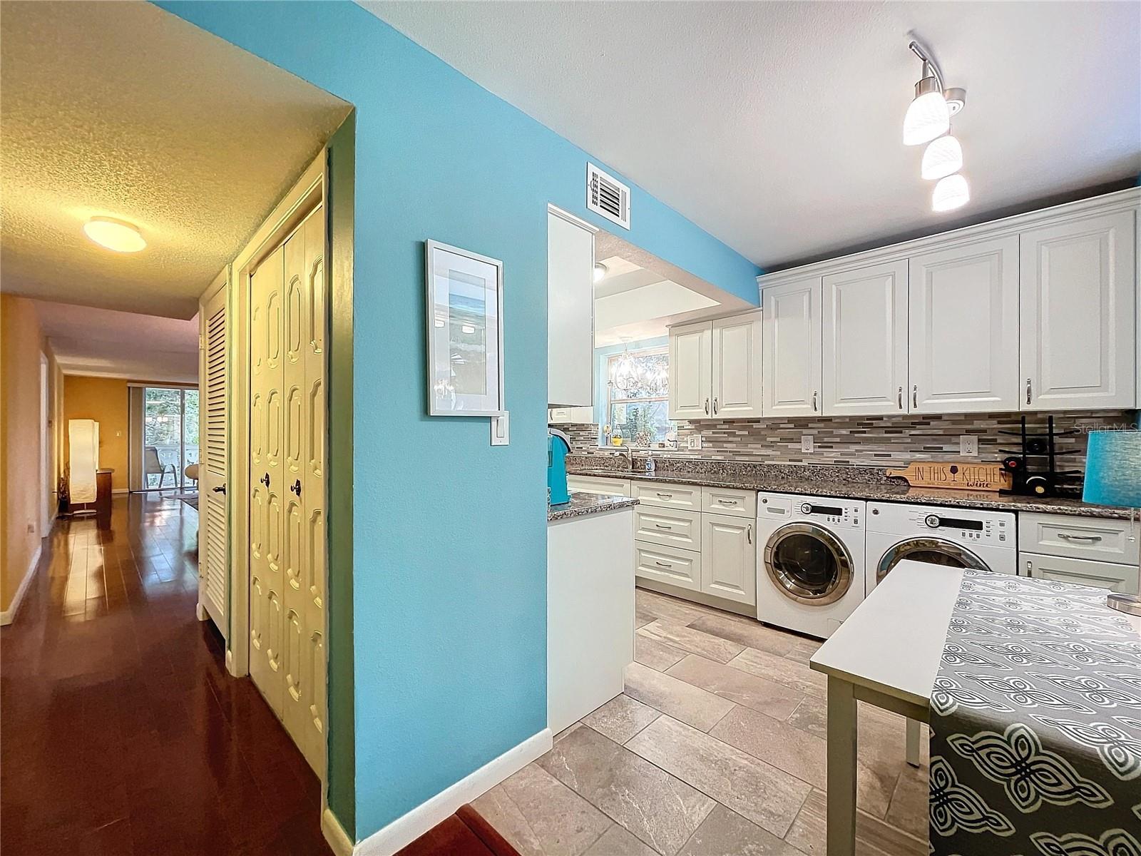 View from the rear of the kitchen into the main hallway highlights the home’s seamless flow and thoughtful layout.