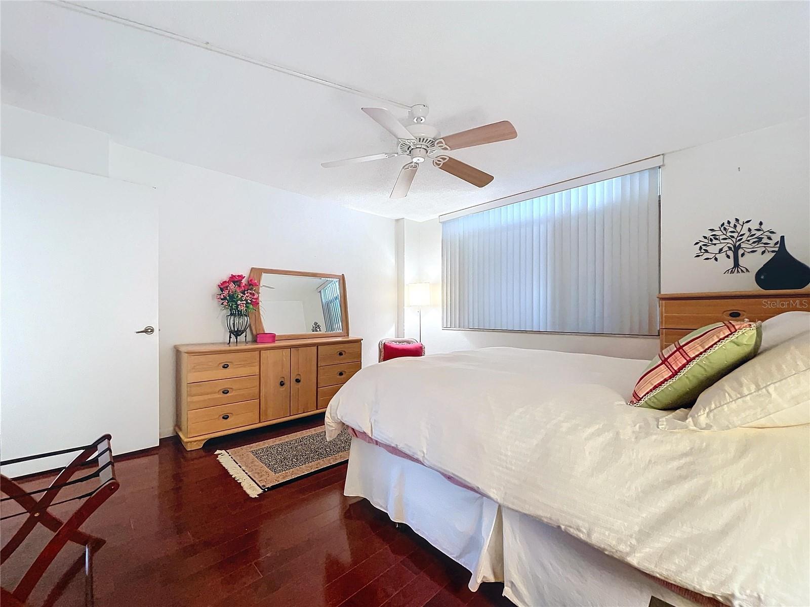 Large window with vertical blinds allows natural light while maintaining privacy, ideal for restful evenings.