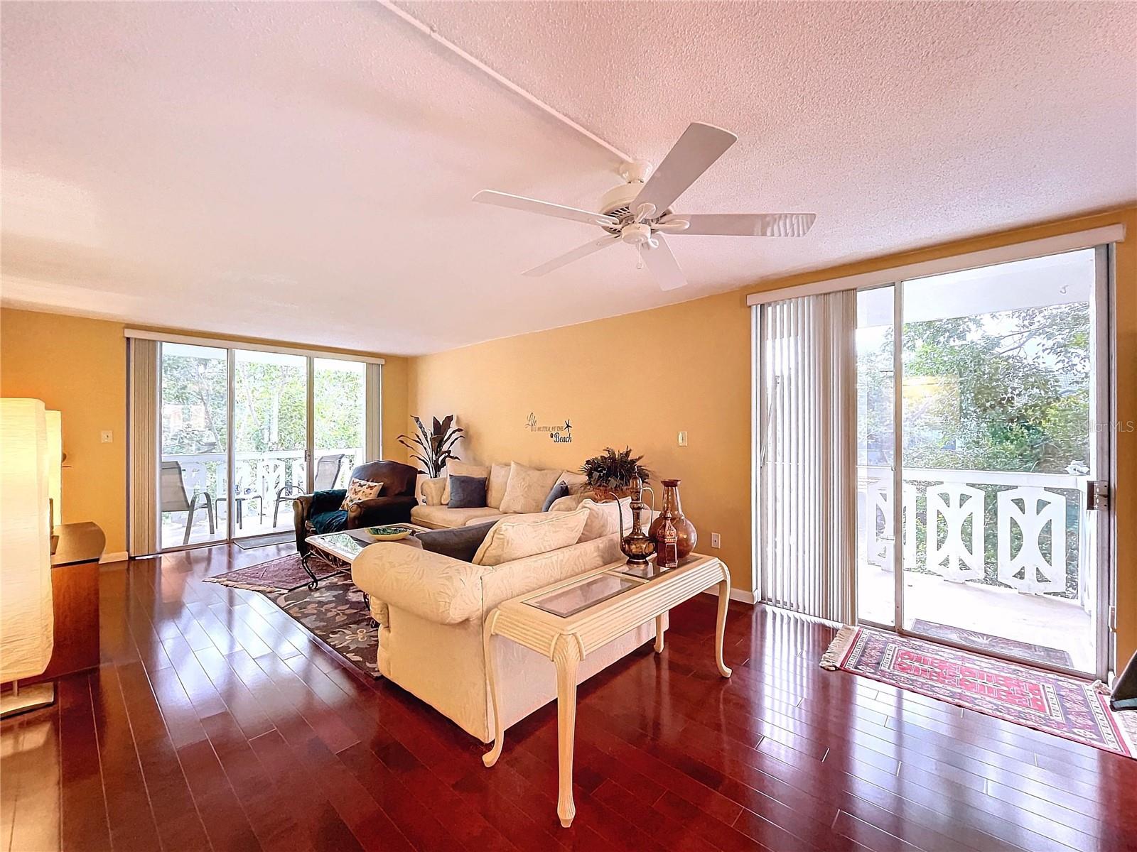Enjoy natural light and tree-lined views through dual sliding glass doors, enhancing the room’s connection to the outdoor balcony.