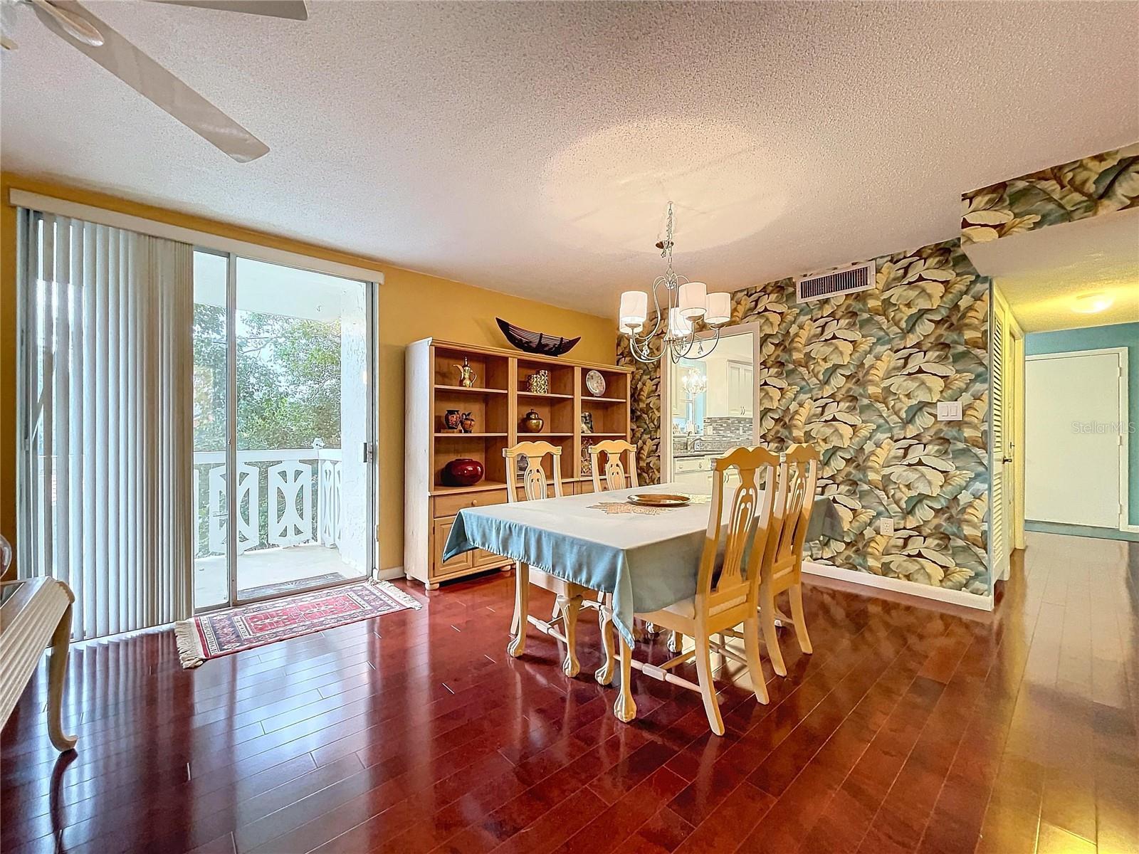 This angle highlights the unique tropical-themed accent wall, adding character to a space that effortlessly connects to the kitchen.