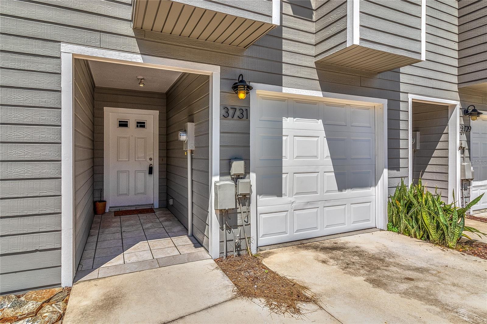 Covered entry, middle unit with one car garage.