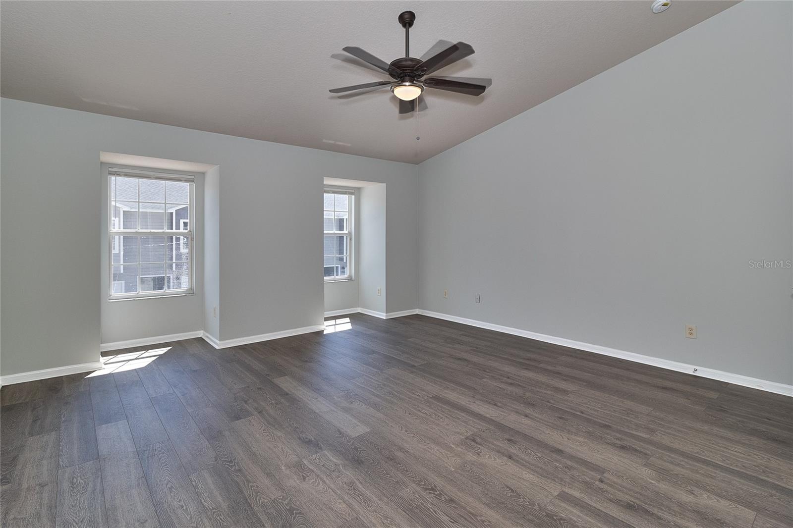 Primary bedroom w/vaulted ceiling.