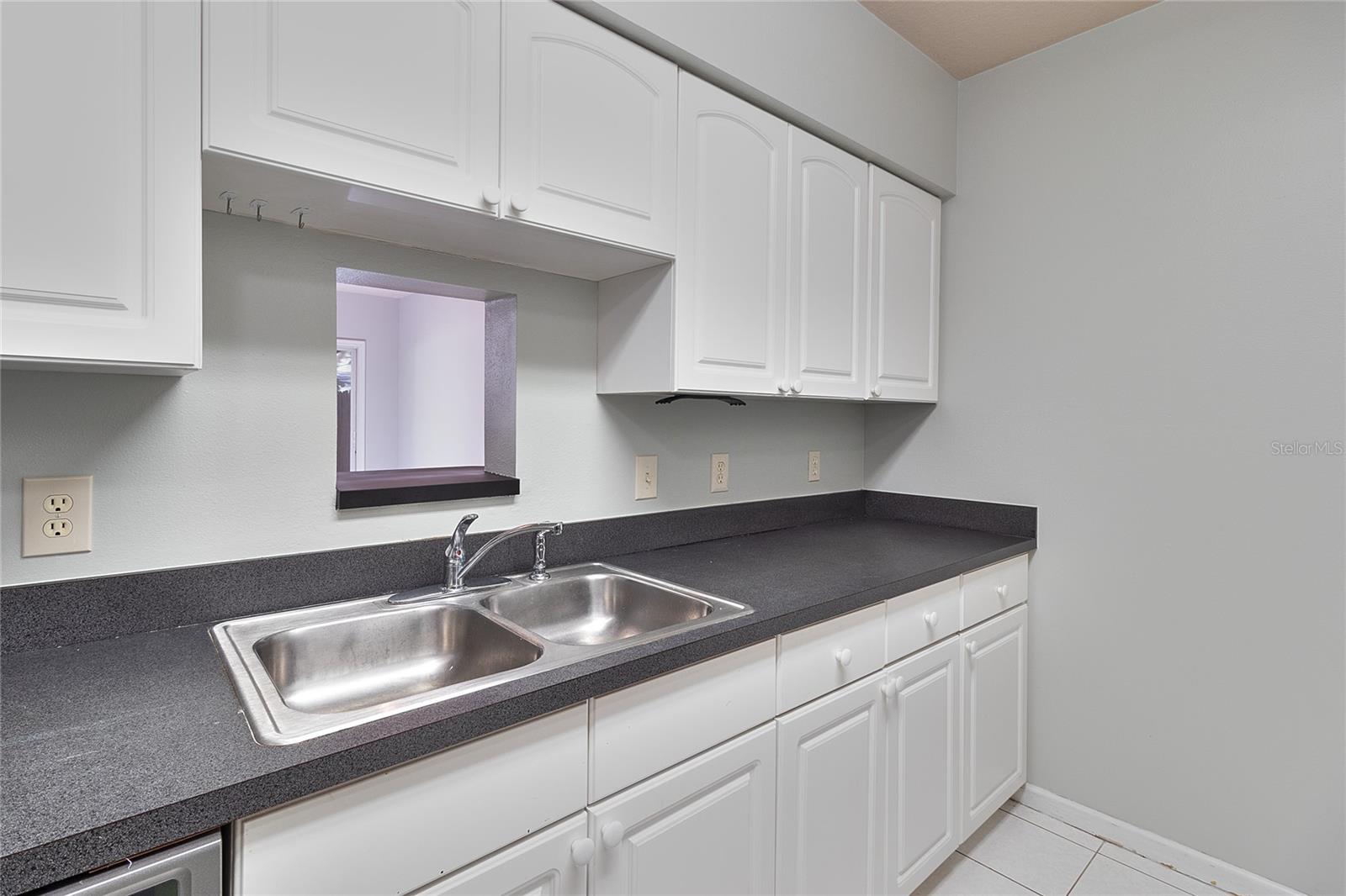 Lots of kitchen cabinets with kitchen pass-through to living room.