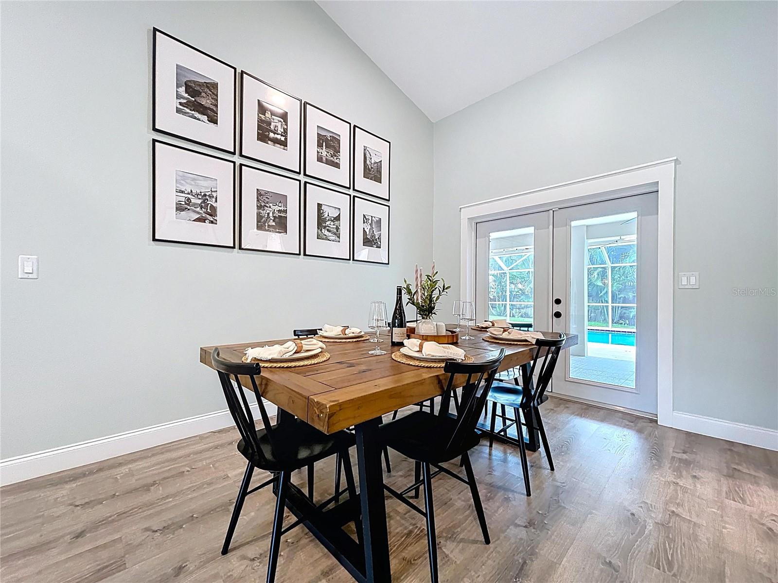 Tastefully staged dining area showcasing high ceilings, minimalist trim, and easy flow into the living room.