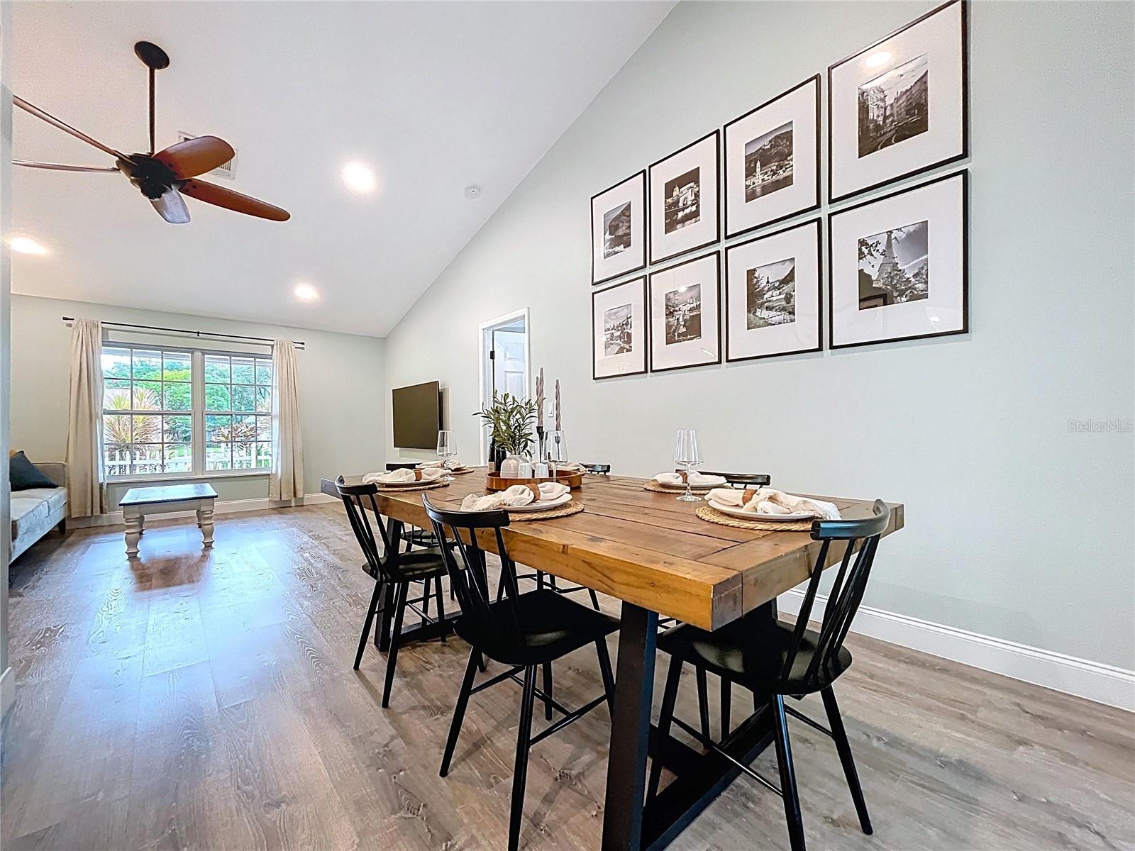 Warm and welcoming open layout perfect for gathering, with rich-toned flooring and large windows drawing in natural light.