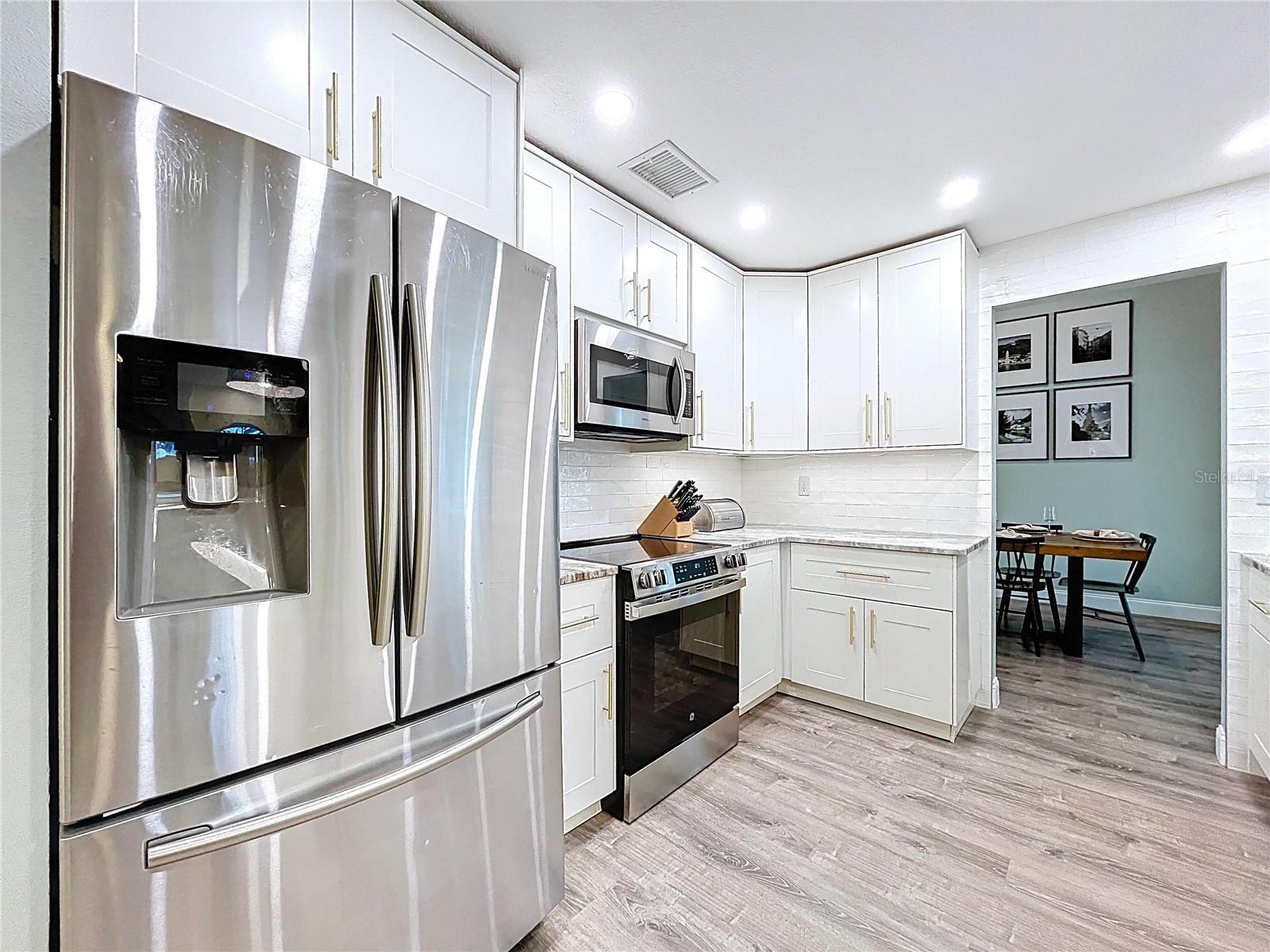 Contemporary kitchen with stainless steel appliances, shaker-style white cabinetry, and modern hardware for a sleek finish.