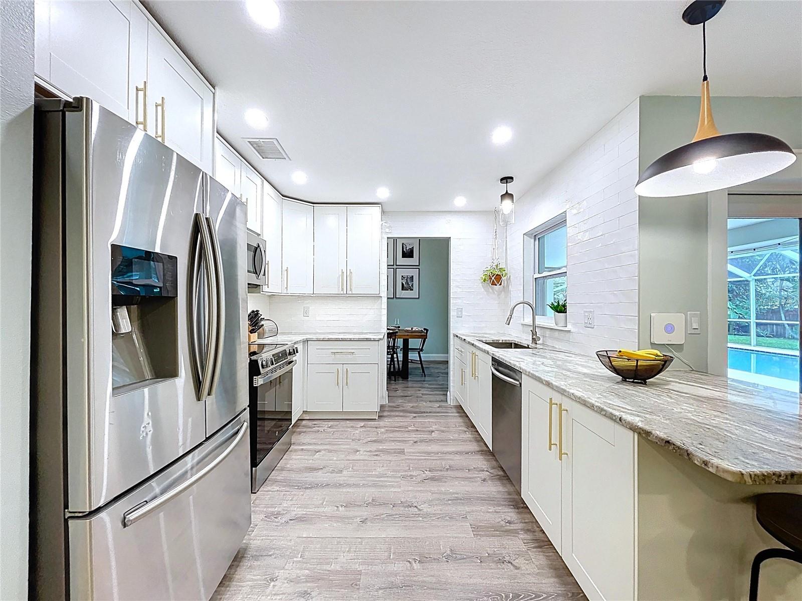 Bright and functional kitchen featuring GRANITE countertops, under-cabinet lighting, and ample cabinet storage.