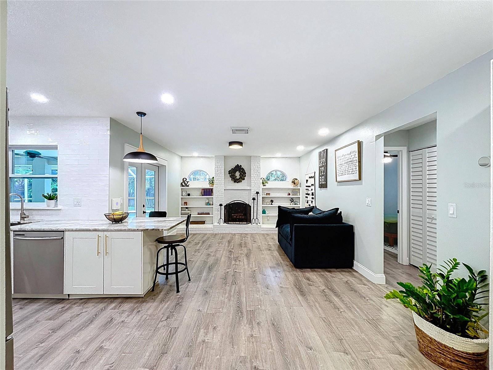 Open-concept kitchen flows into the cozy family room, with a large peninsula, pendant lighting, and counter seating for casual dining.