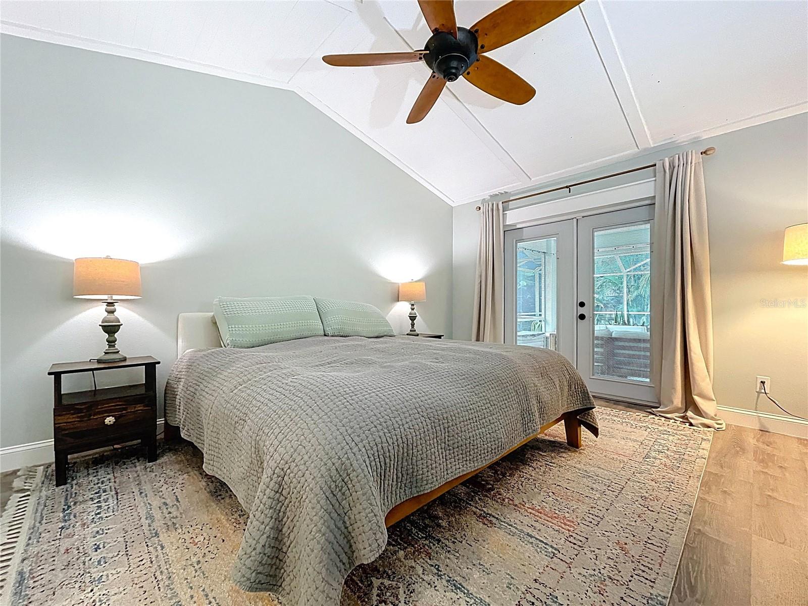 Relaxing retreat featuring vaulted ceilings, a ceiling fan, and direct access to the lanai through elegant French doors.