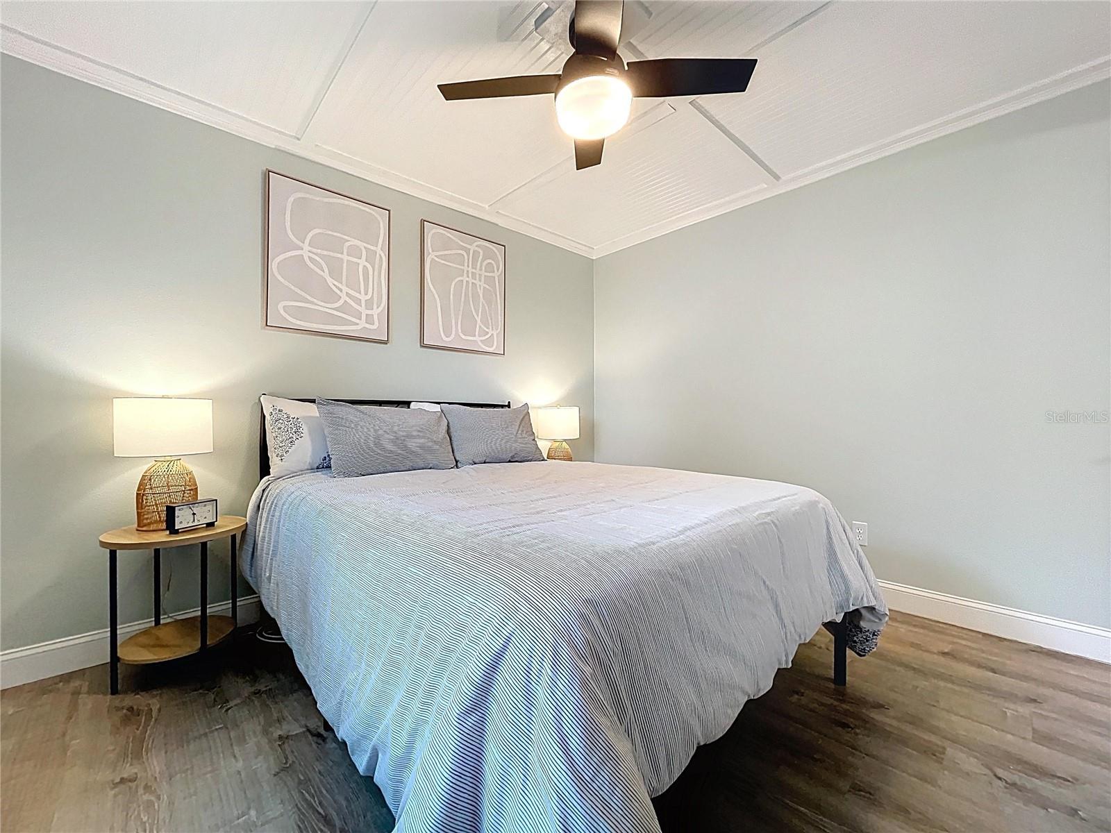 Peaceful guest retreat featuring a soft color palette, natural light, and matching nightstands with accent lighting.