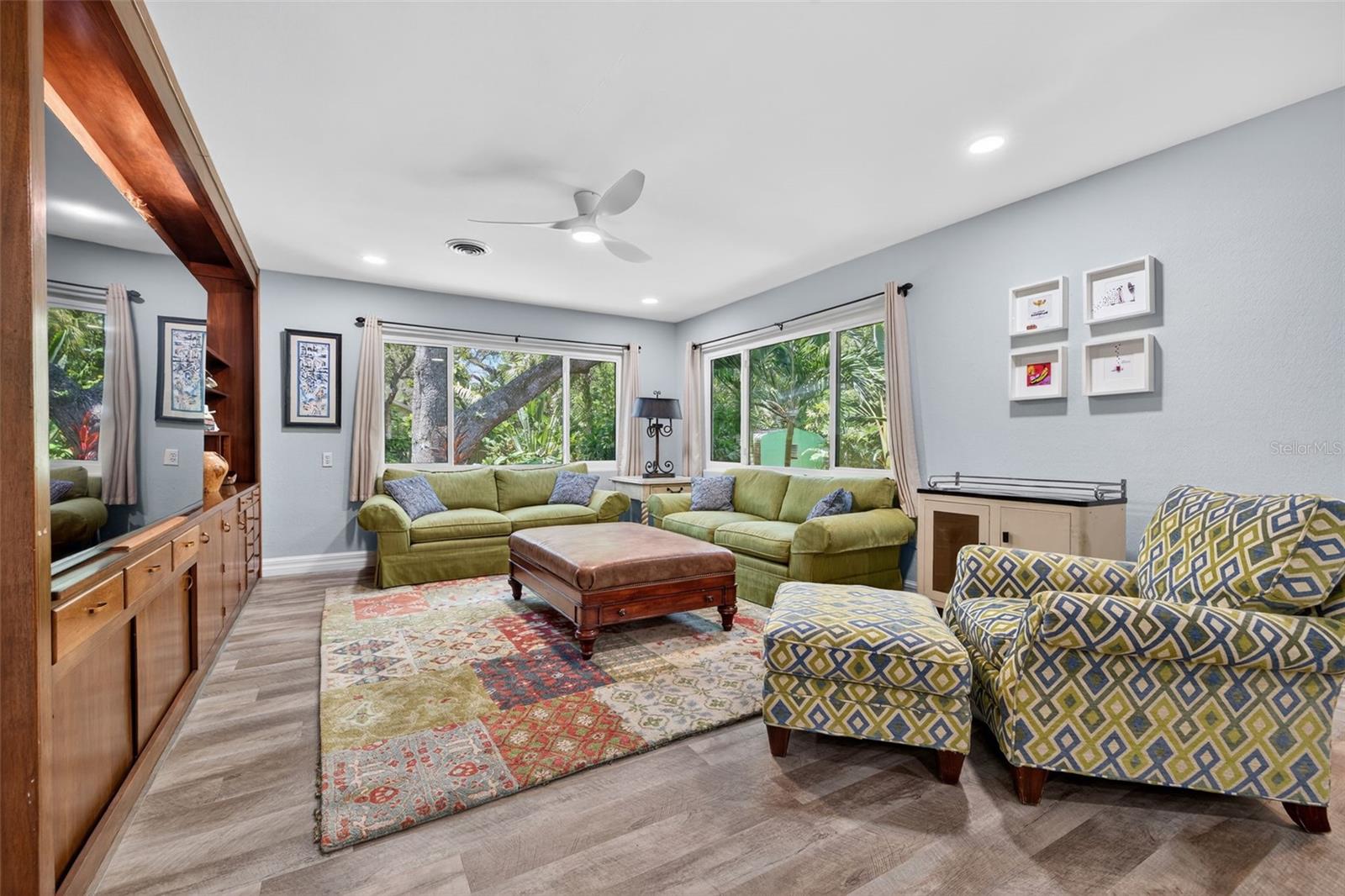 Living Room with large picture windows of the Tropical Oasis in the Backyard