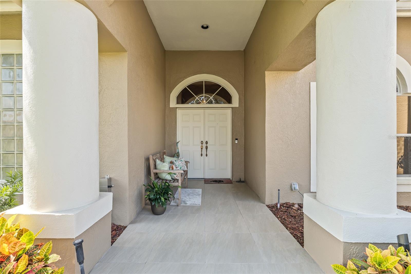 The front approach provides a grand entrance among a bubbling fountain and double doors.