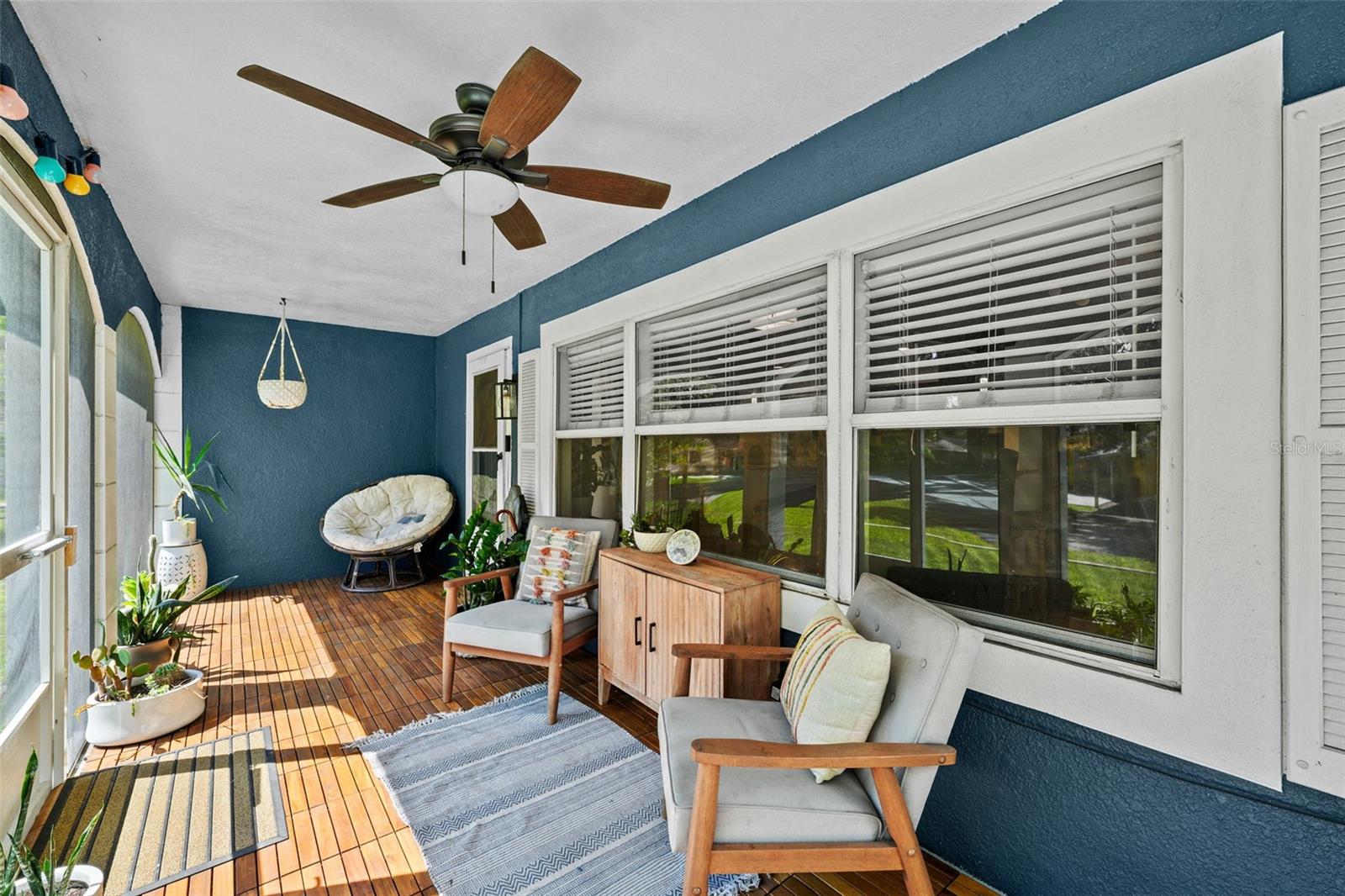 Beautiful teak flooring accentuates this spacious enclosed porch.