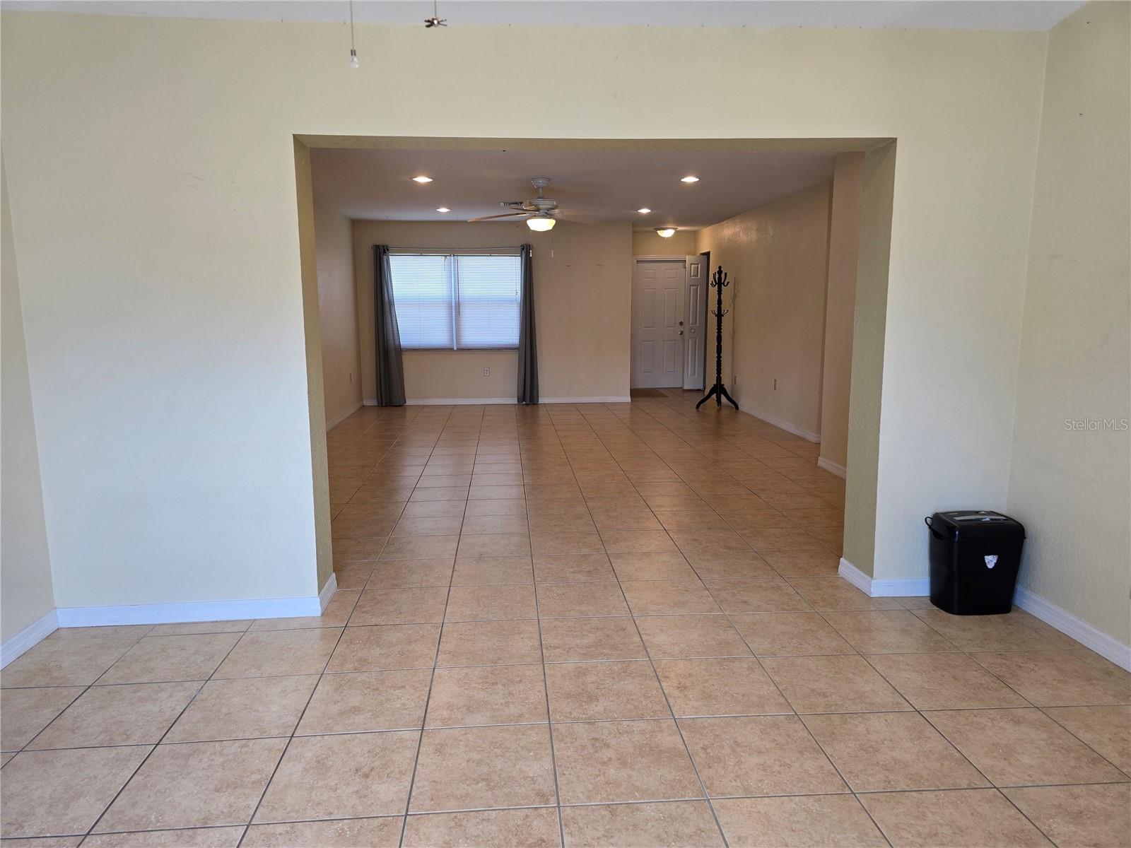 Looking to front door area/garage (on far right) through living room from dining area