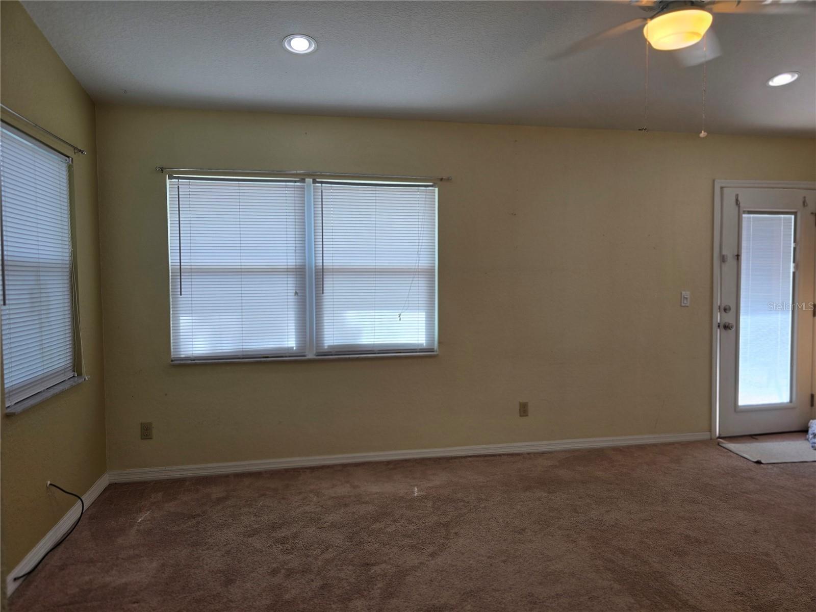 Primary bedroom, lots of windows to back yard, and a door for private access