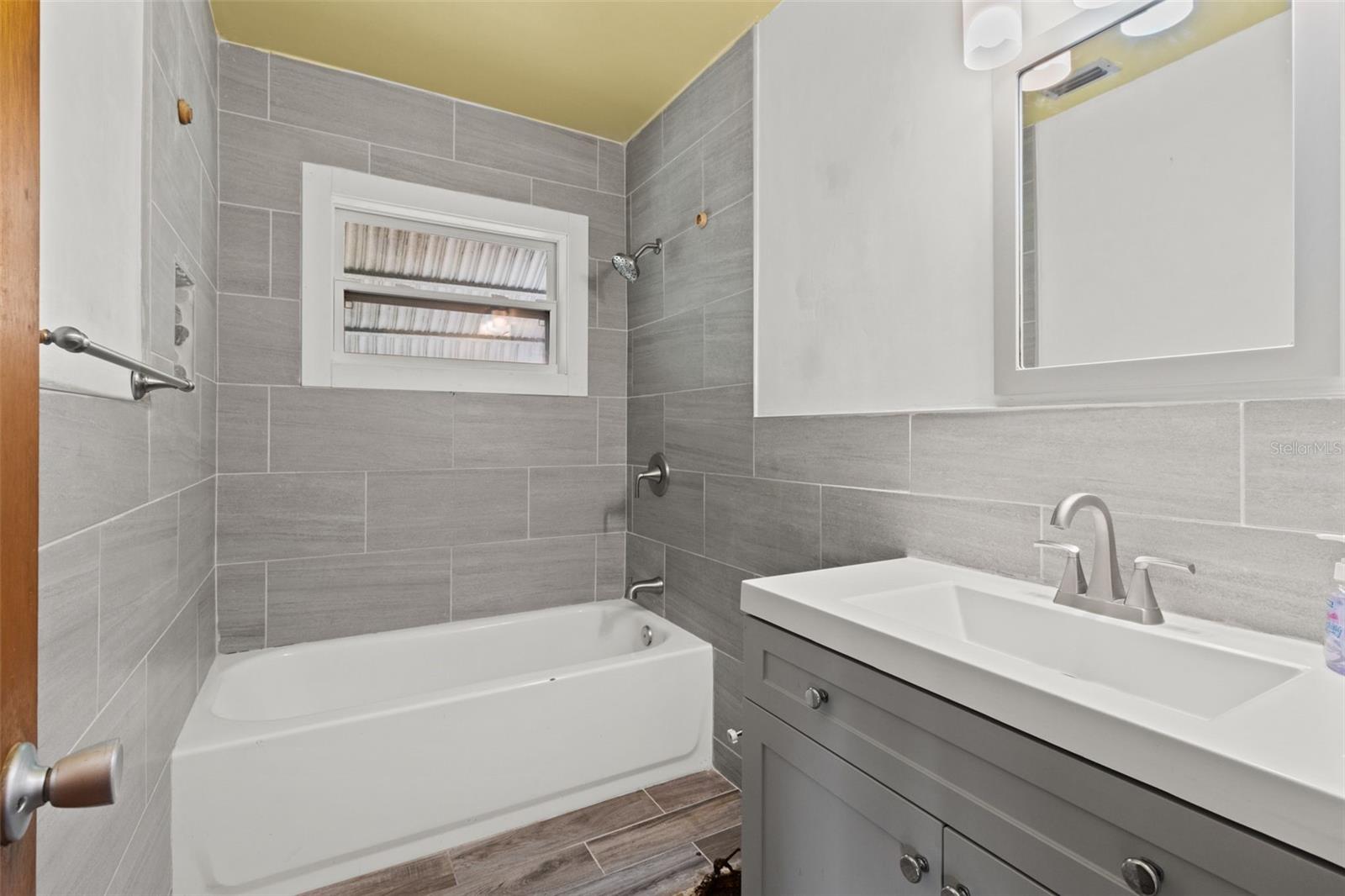 Renovated second bathroom in hallway is missing the toliet.