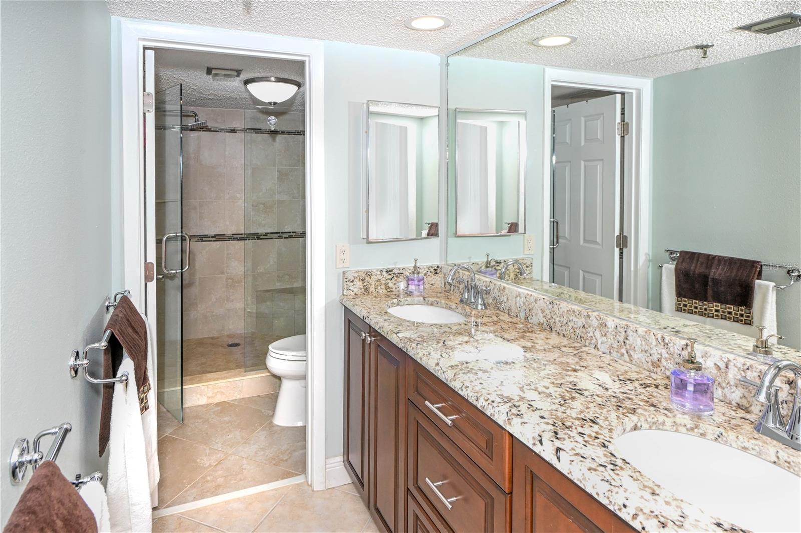 En-suite bath with dual sinks and a step in shower