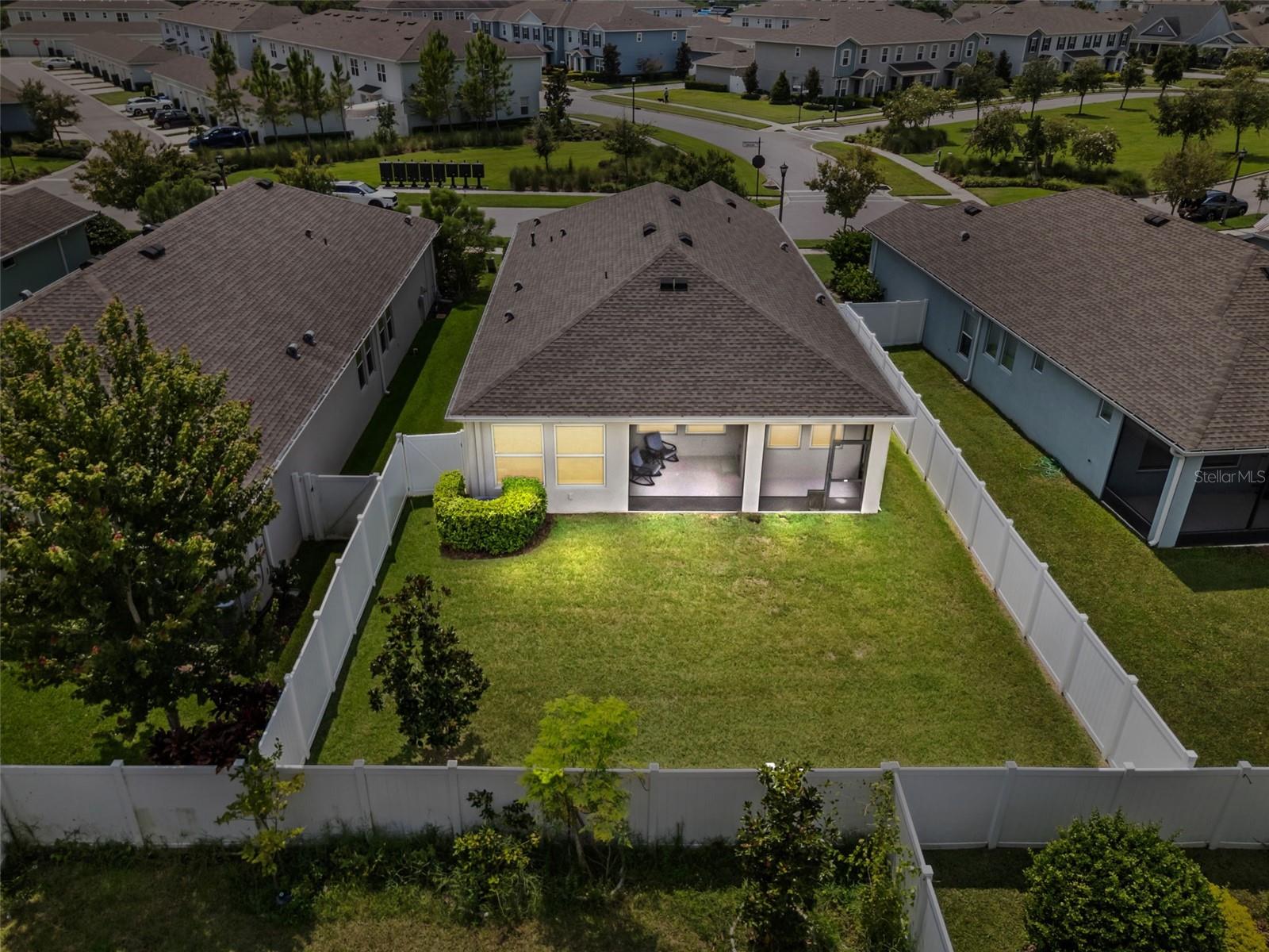 Large fenced in backyard with screened lanai