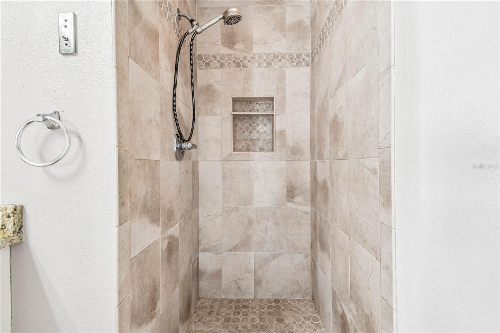 Primary bathroom has a beautifully tiled walk in shower.