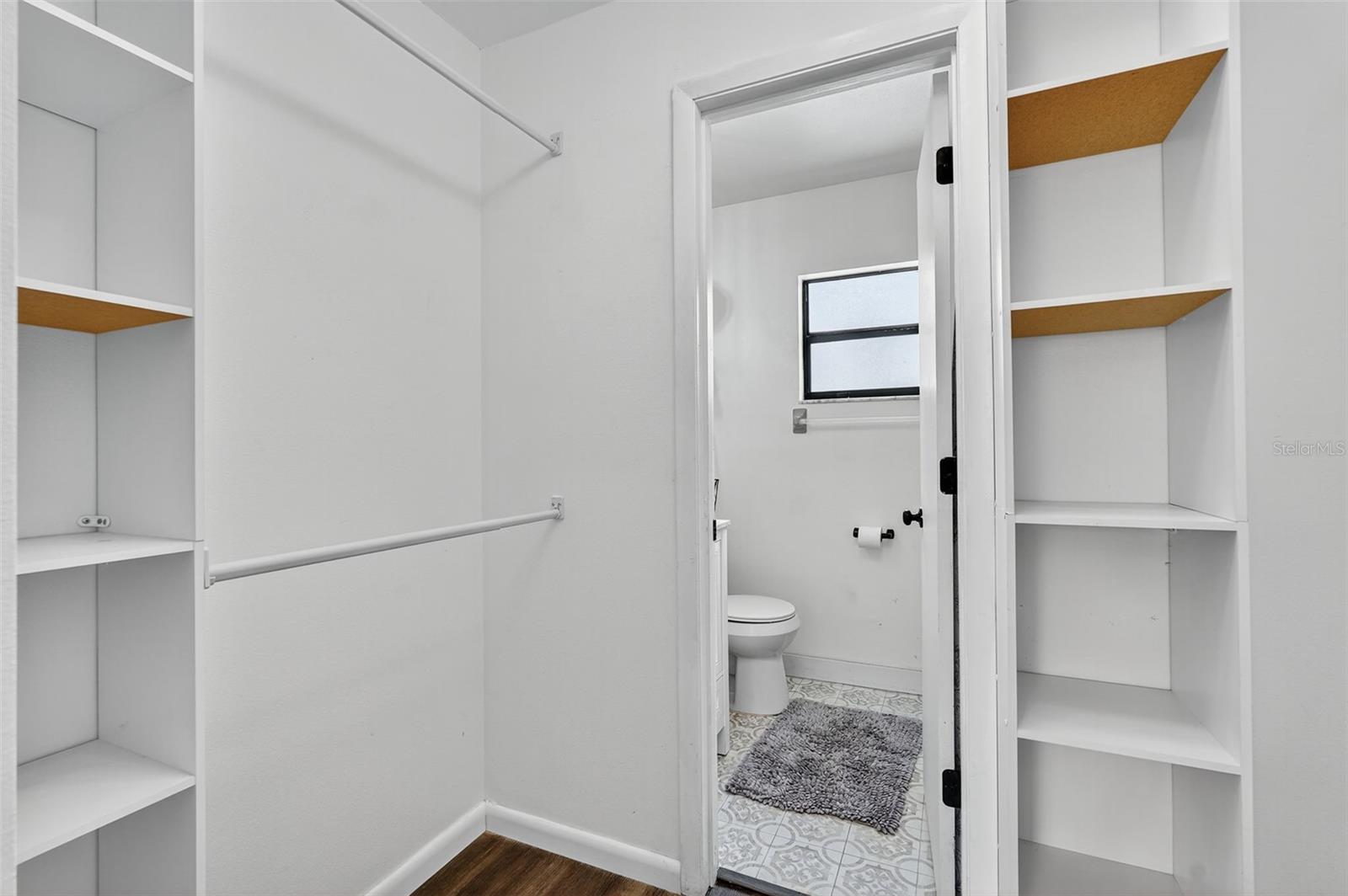 Primary Suite walk in closet leading into bathroom