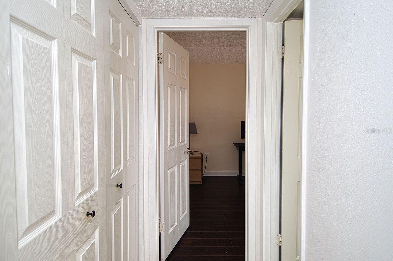 Hallway to Guest Bedroom.  Laundry closet to your left behind double doors