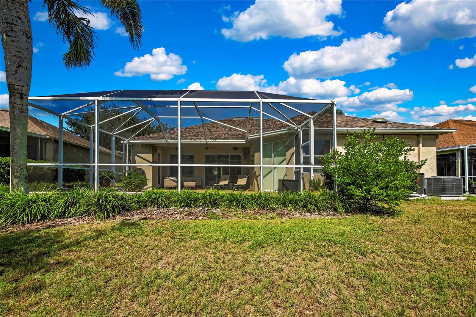 backyard view of the enclosed lanai with pool
