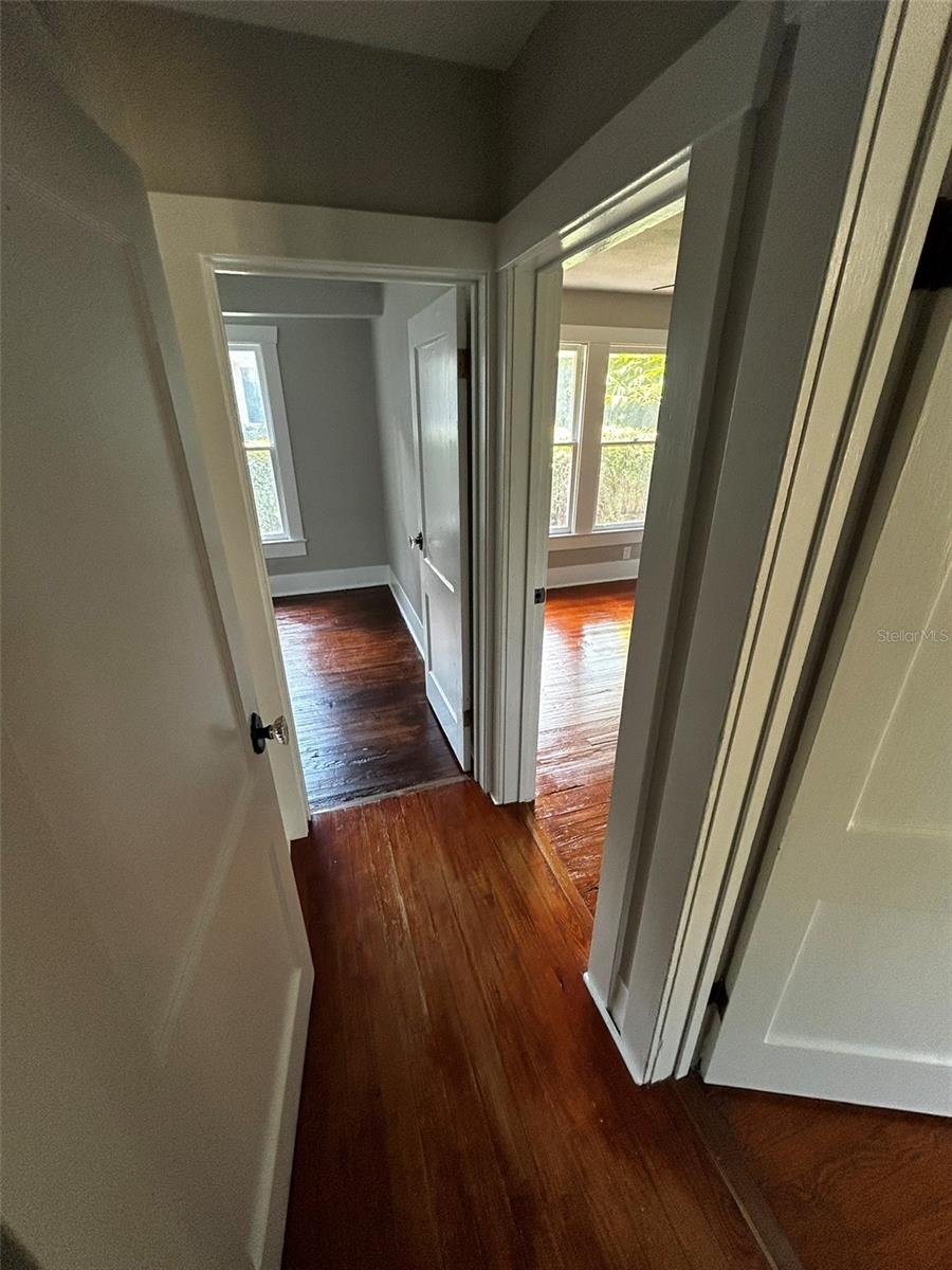 Hallway connecting dining room to bathroom (R) and two bedrooms