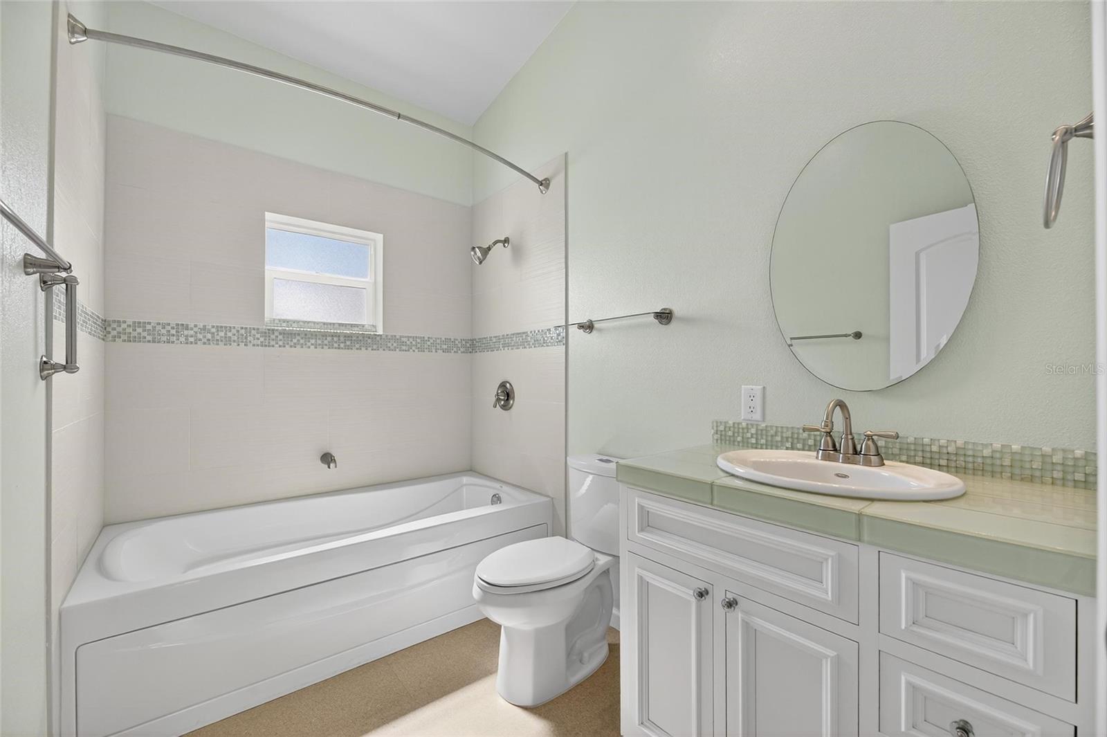 Second ful bathroom offers a jetted tub and bright sunlight for relaxation.