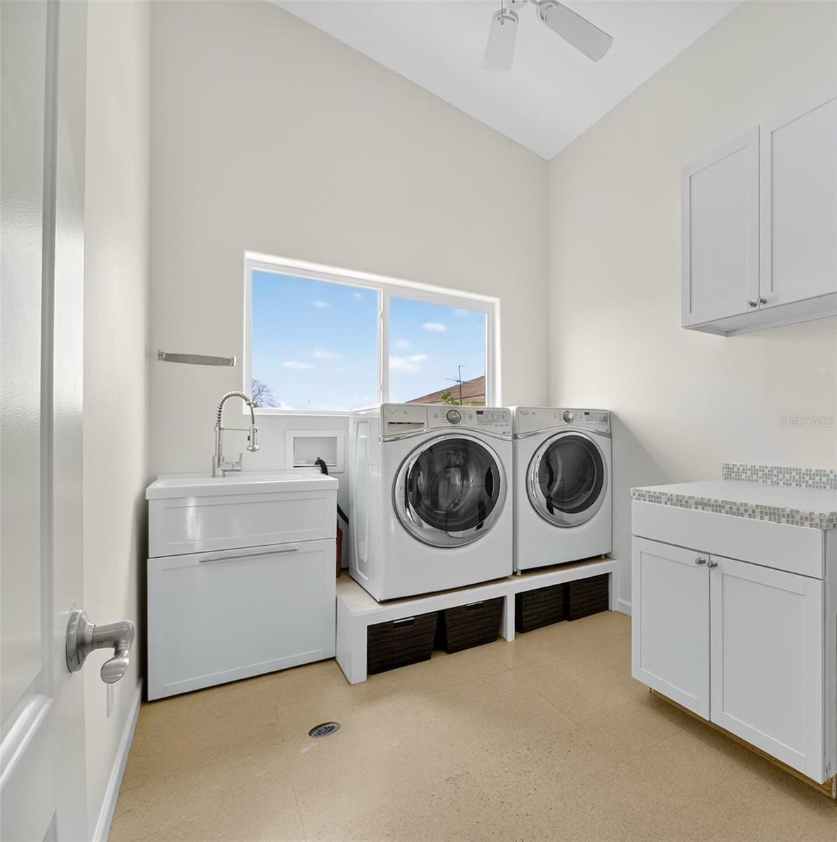 Utility room complete with utility sink, storage and cork flooring is conveniently located upstairs just off the foyer.