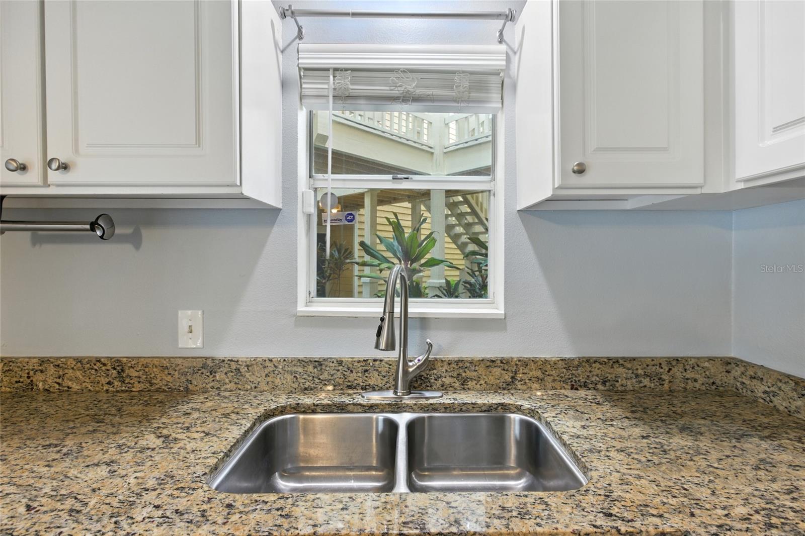 Kitchen window brings in natural light right above the sink and great view of the landscaped courtyard!