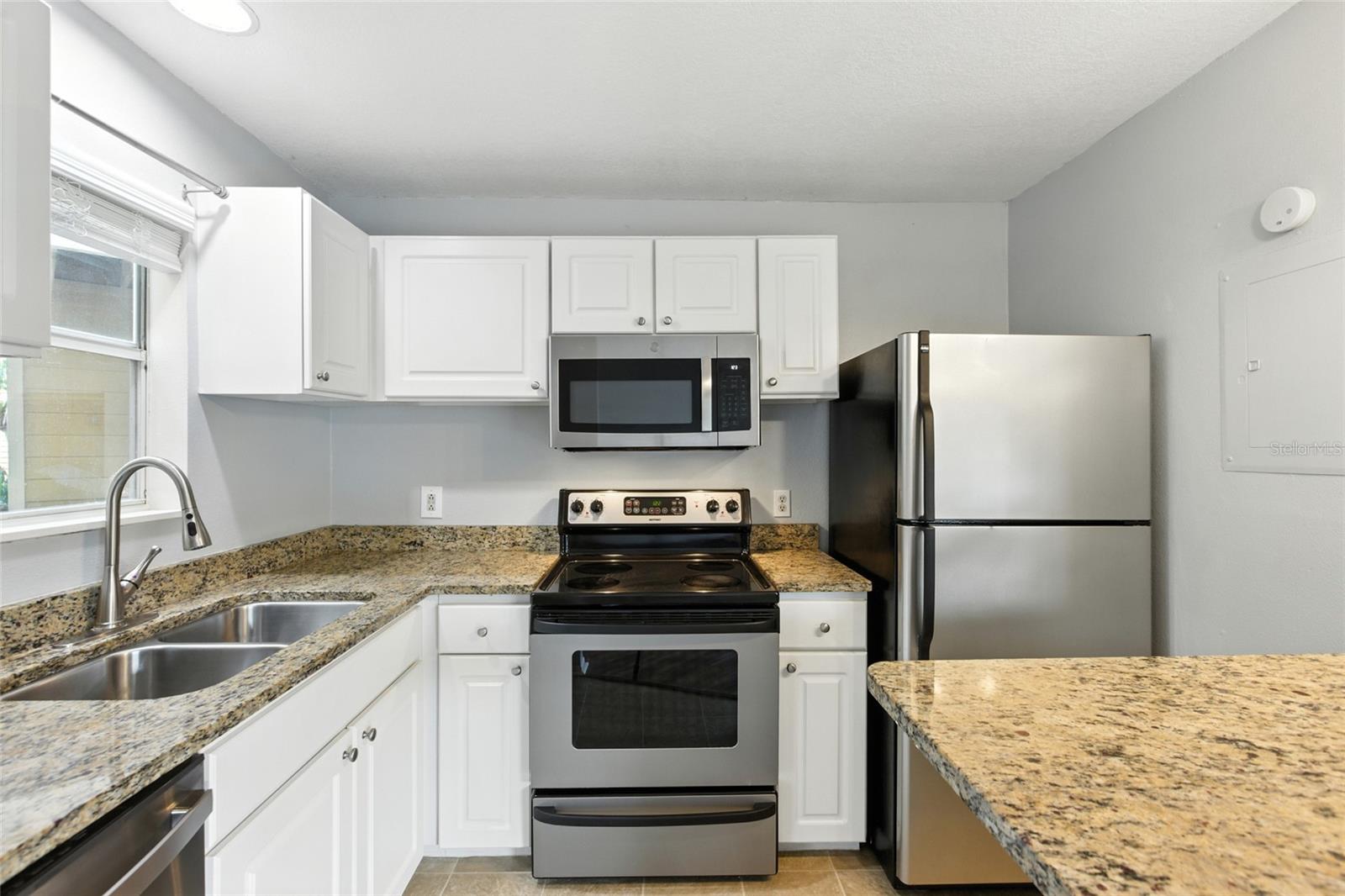 Crisp white cabinetry and granite counters keep the kitchen feeling fresh.