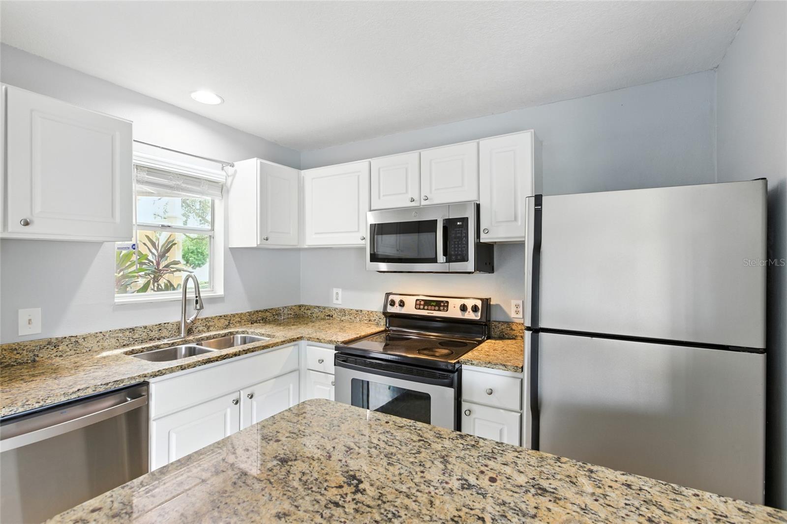 Stainless steel appliances and crisp cabinetry keep the kitchen feeling fresh