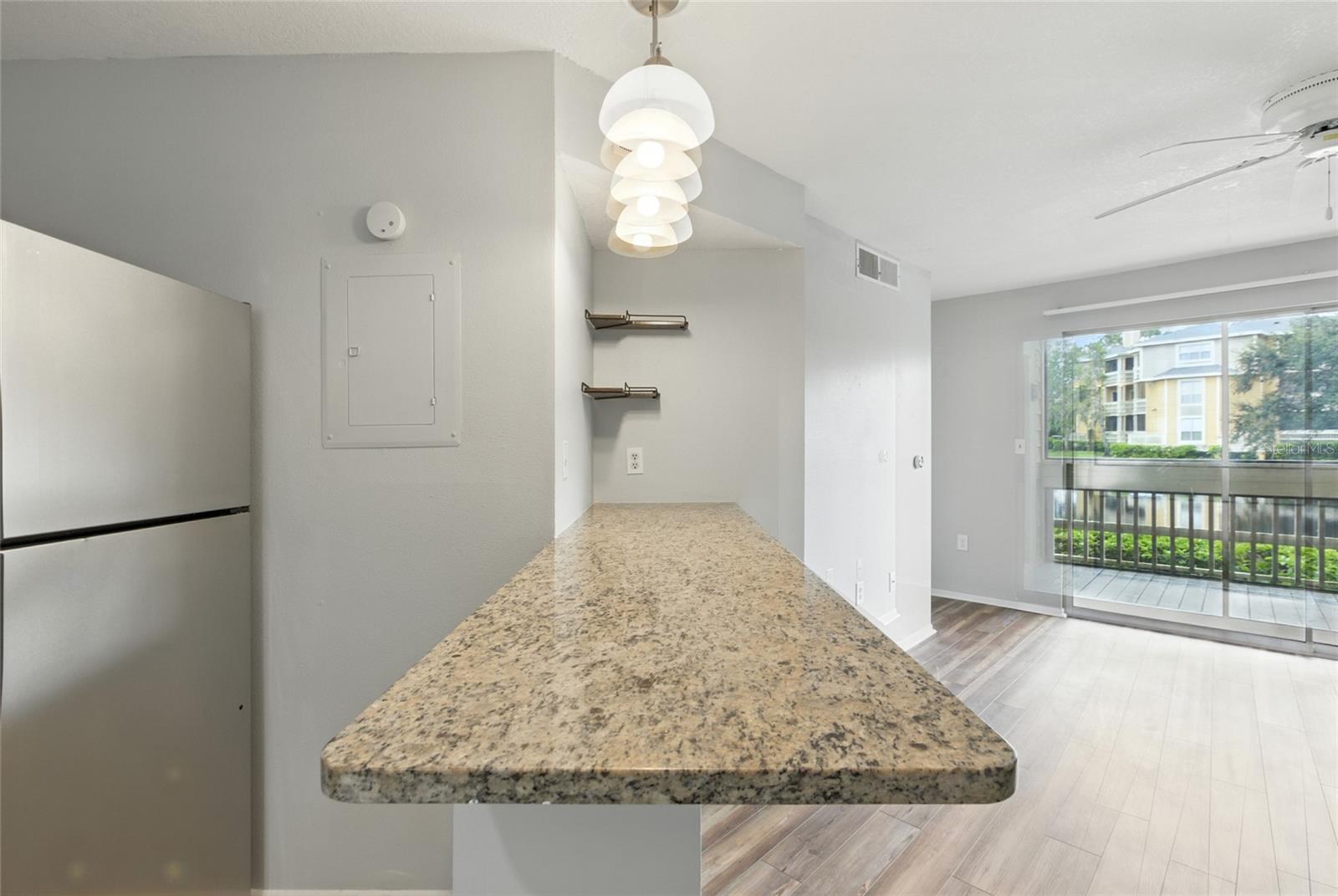 Pendant lighting and a built in granite breakfast bar create a natural gathering spot