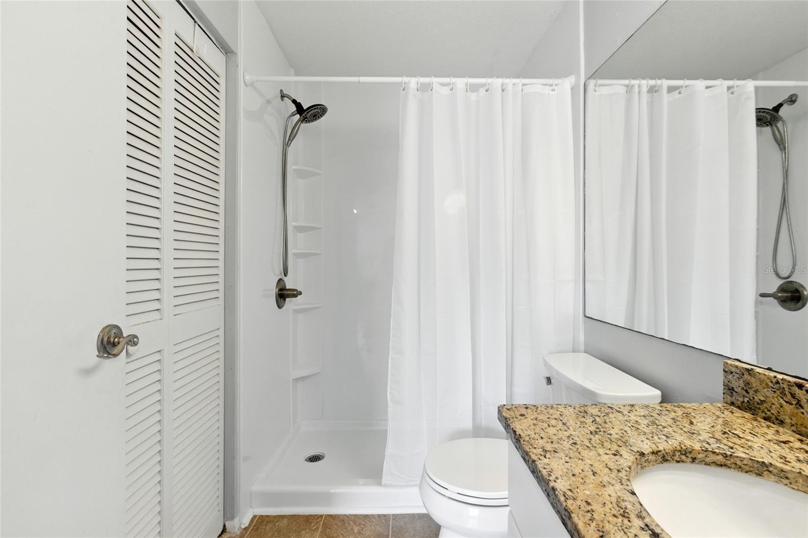 Walk-in shower with shelving and updated fixtures