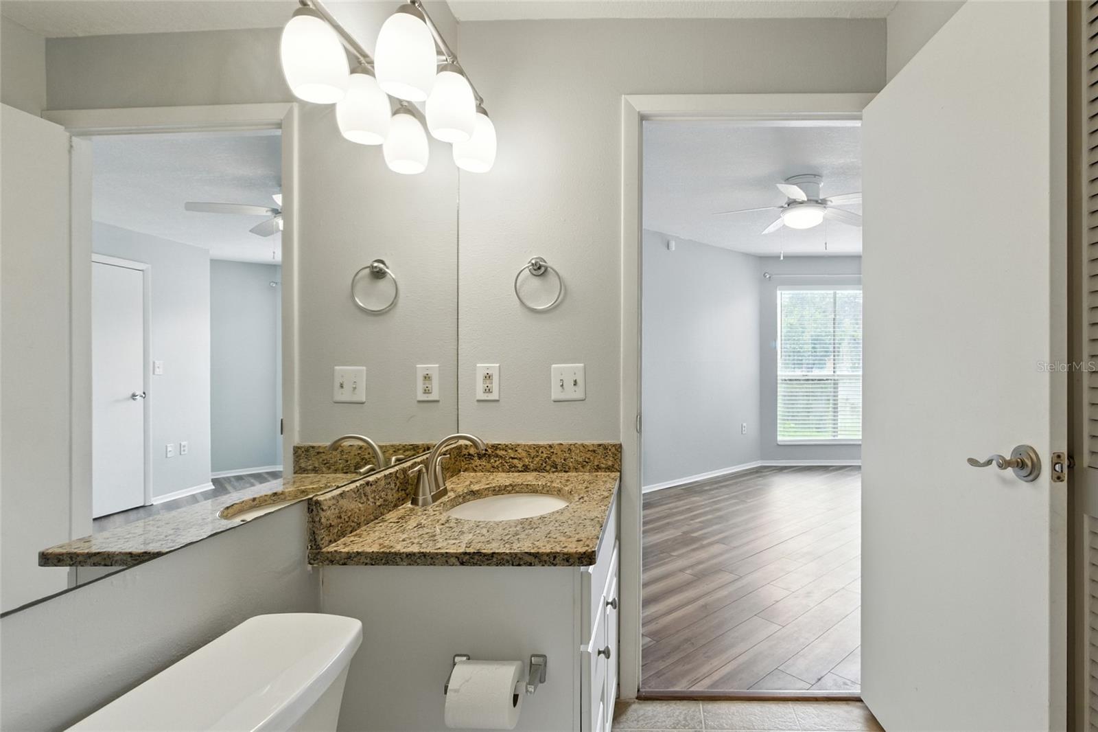 Granite vanity with wide mirror and storage