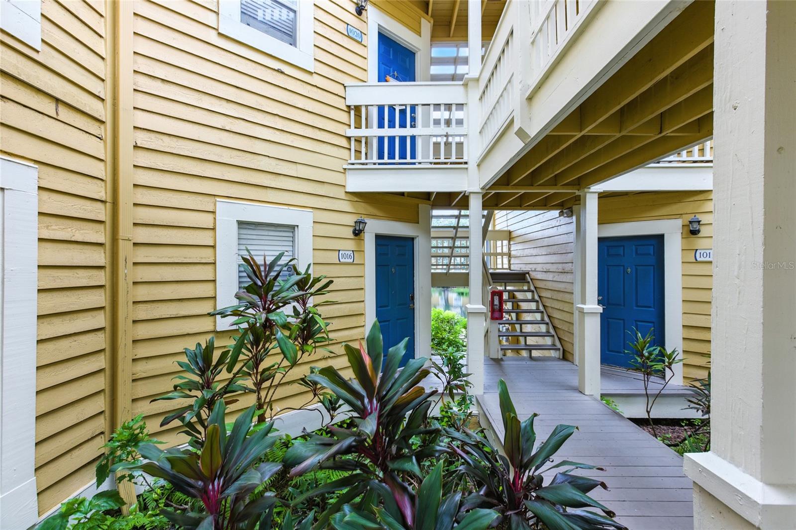 Private walk-up entry framed by tropical landscaping — no long, hotel-style hallways here