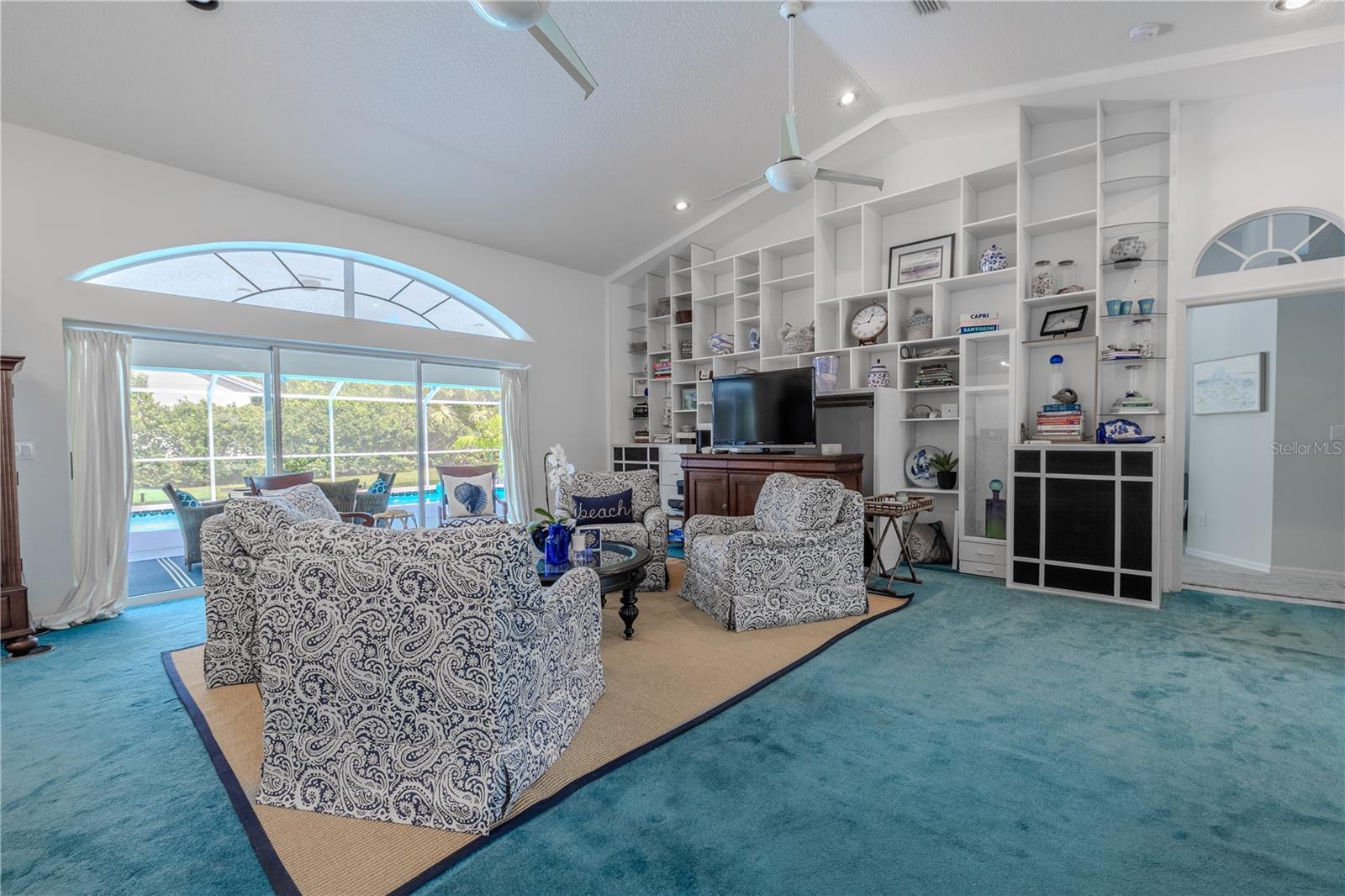 The living area showcases a full wall of built-in shelving, perfect for displaying décor, creating a home library, or adding organized storage to the heart of the home.