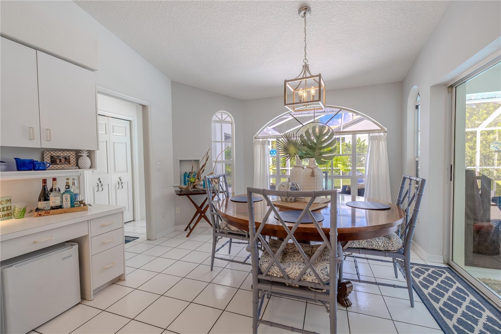 The eat-in kitchen offers a bright dining space with large windows, pool views, and sliding doors that open to the lanai for easy indoor-outdoor living.
