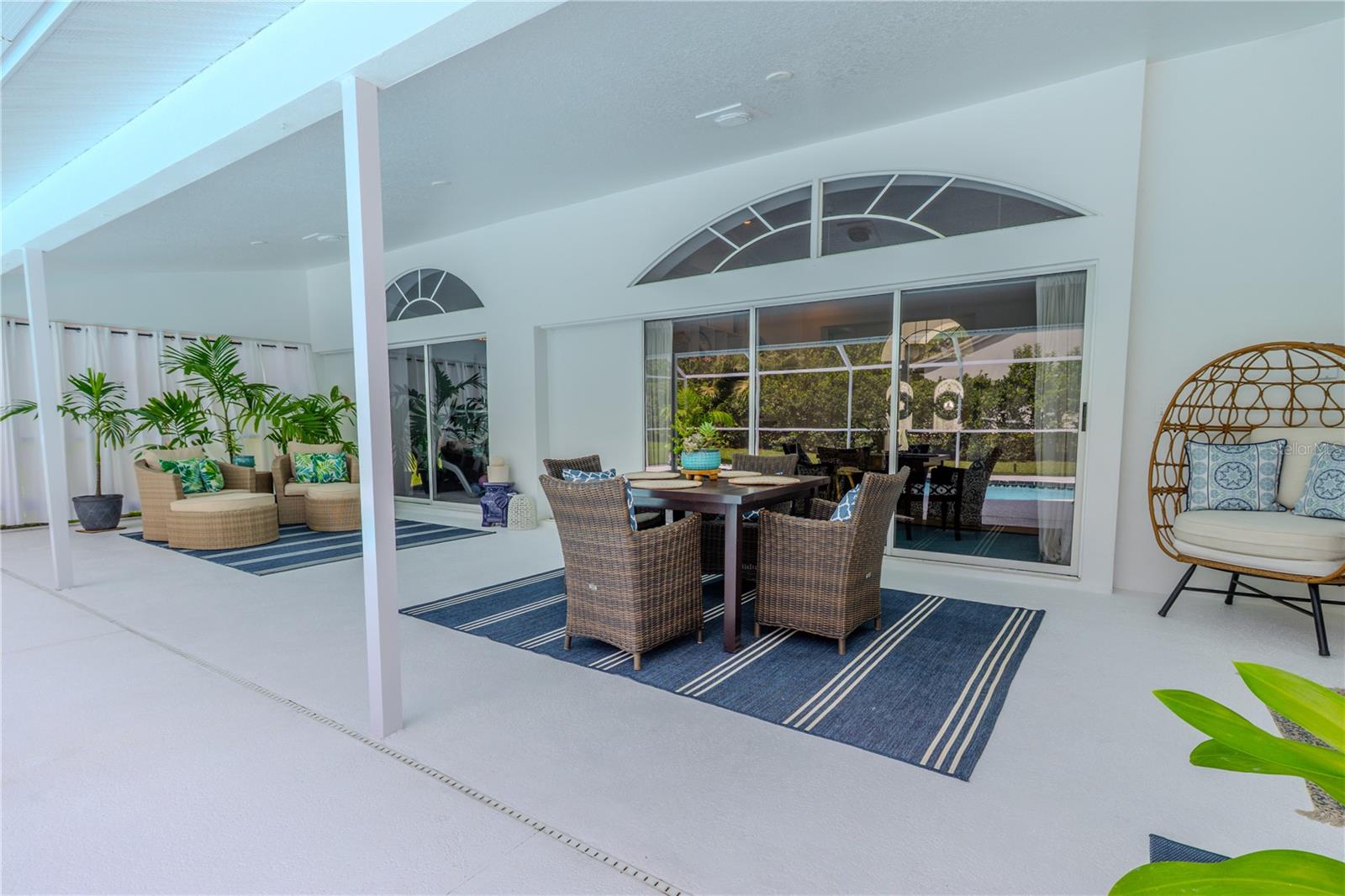 The covered lanai connects seamlessly to the home, with sliding doors leading directly from the primary suite and living room out to the pool area.