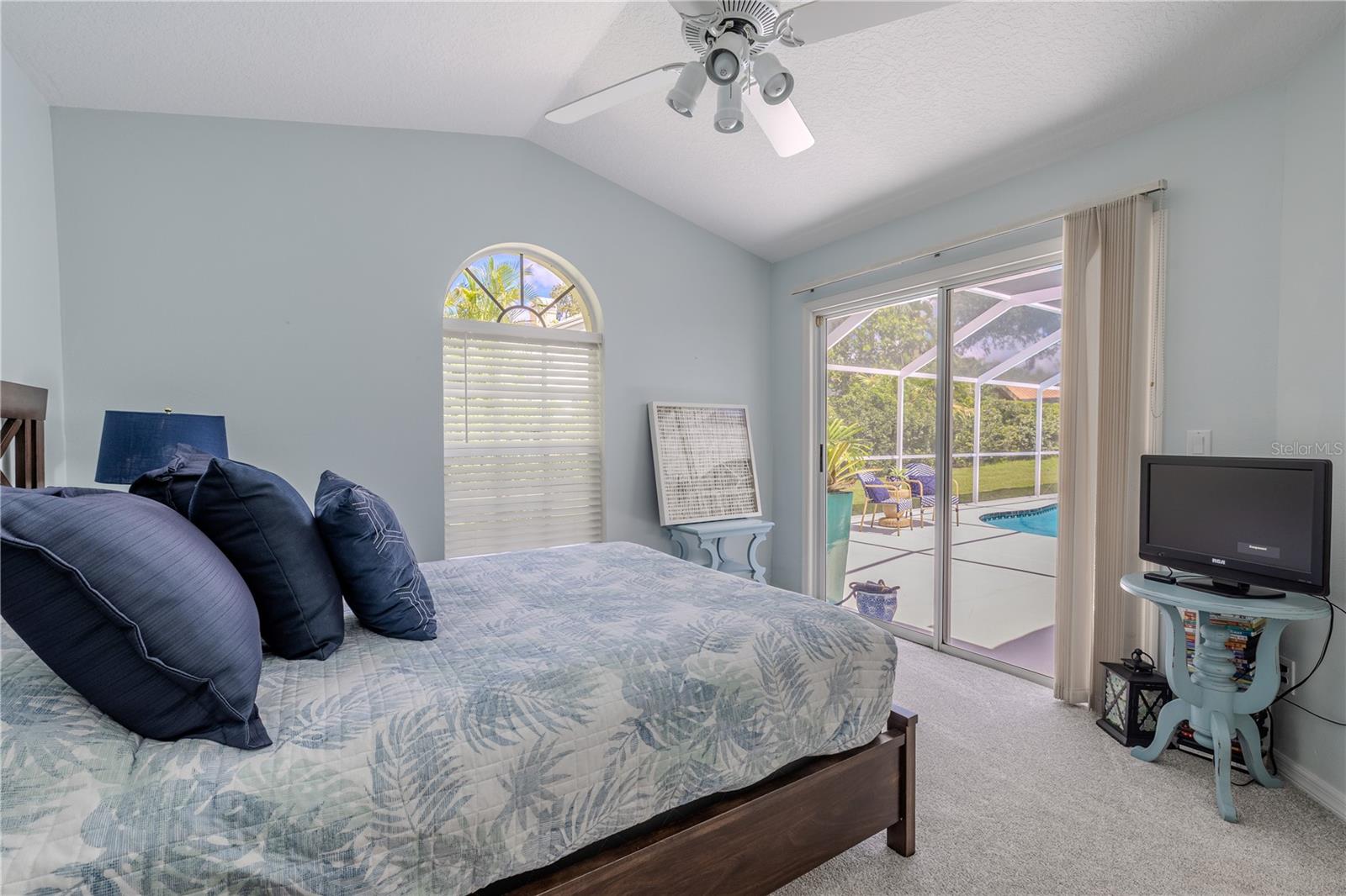 The second bedroom offers direct access to the pool and lanai through sliding glass doors, blending indoor comfort with outdoor convenience.