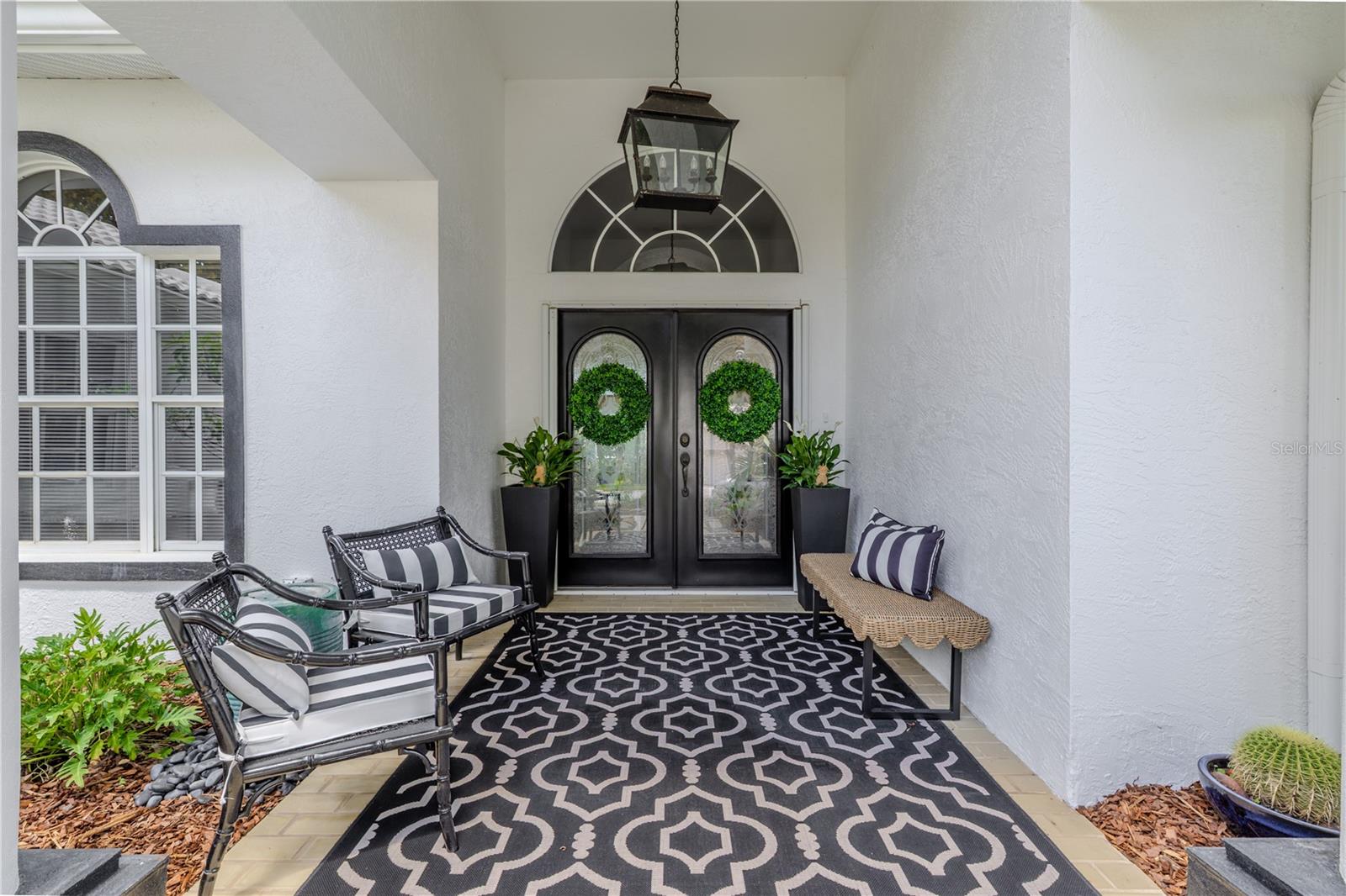 The double glass doors, arched window, and covered entry create a striking first impression that sets the tone for the rest of the home.