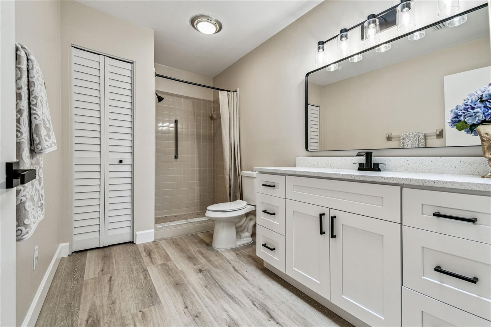 Primary bathroom with all wood vanity, lights, mirror, medicine cabinet, etc.