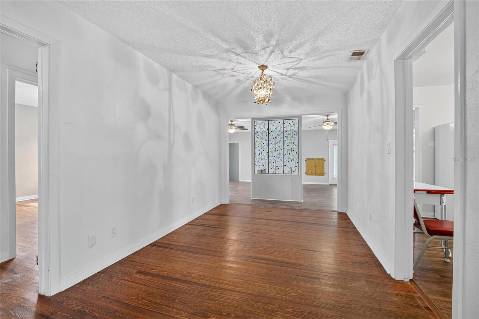 DINING ROOM WITH KITCHEN TO THE RIGHT AND BEDROOMS TO THE LEFT