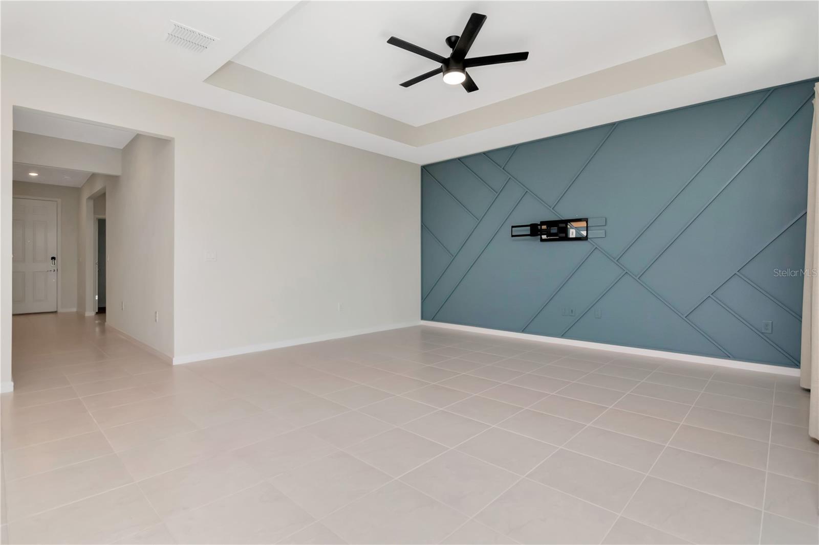 Living Room with Tray Ceiling, Decoartive Accent Wall and Ceiling Fan