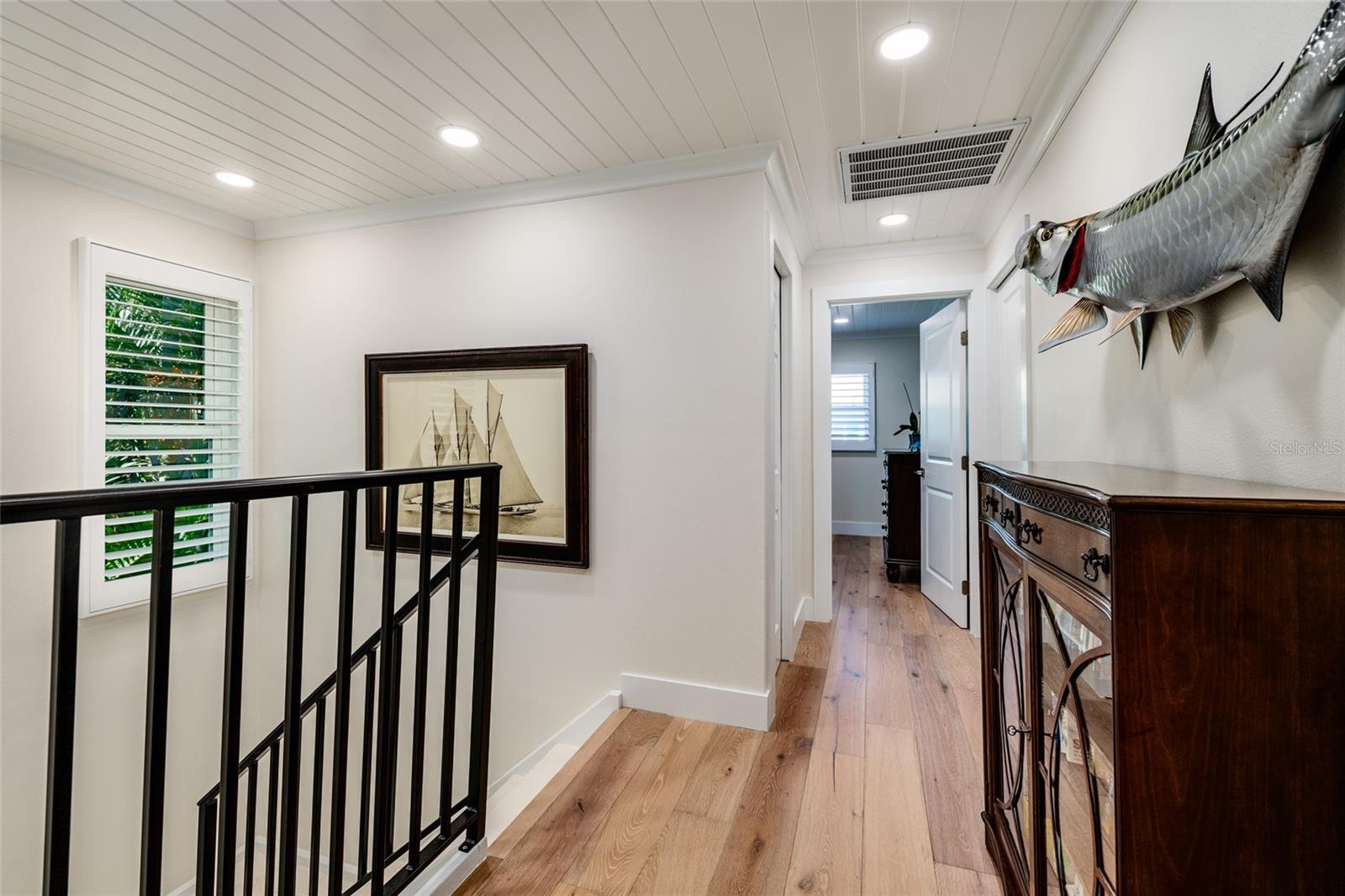 Bright landing with wood floors and open rail detail