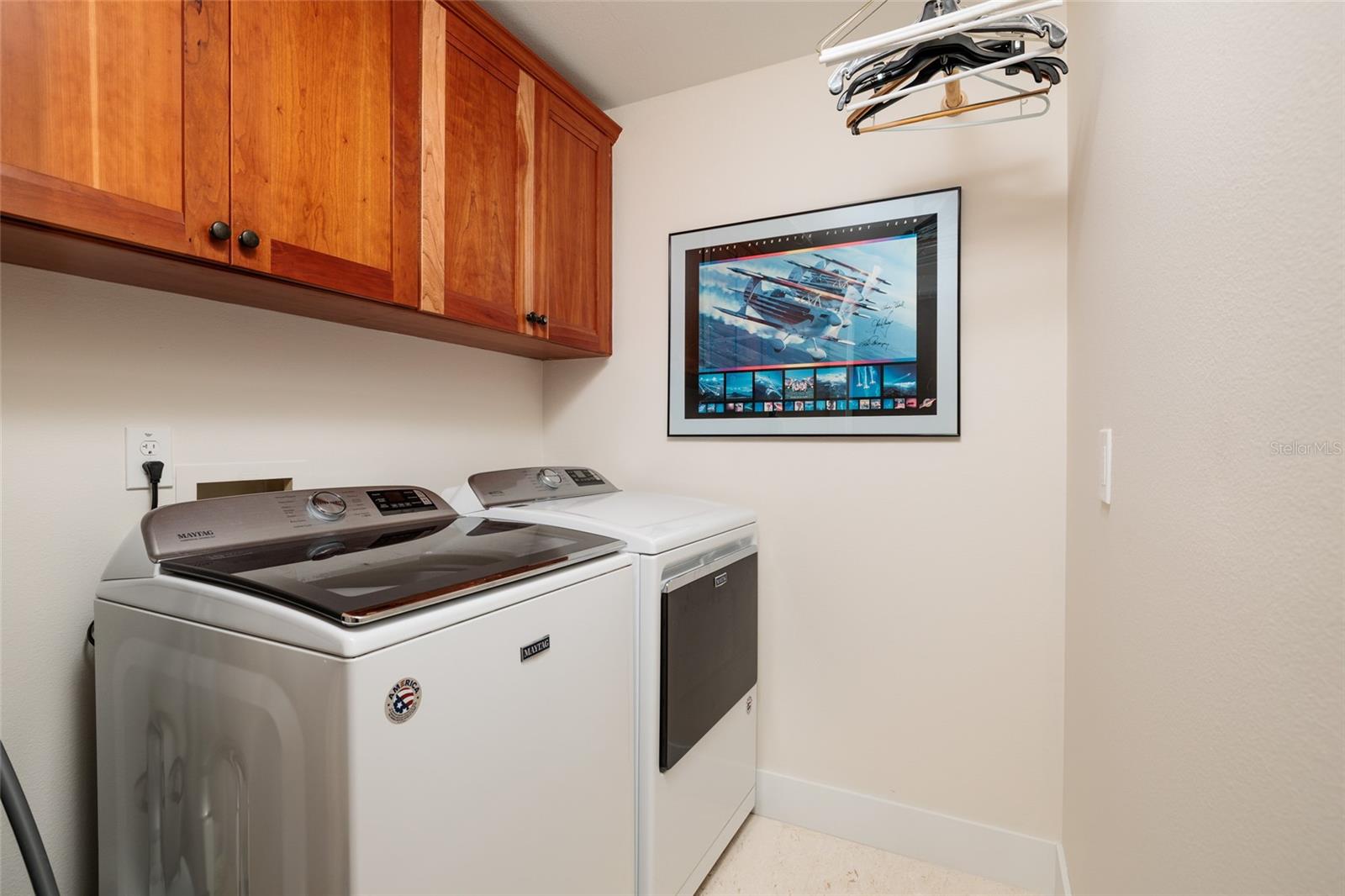 Full-size washer/dryer with storage cabinetry on 2nd floor