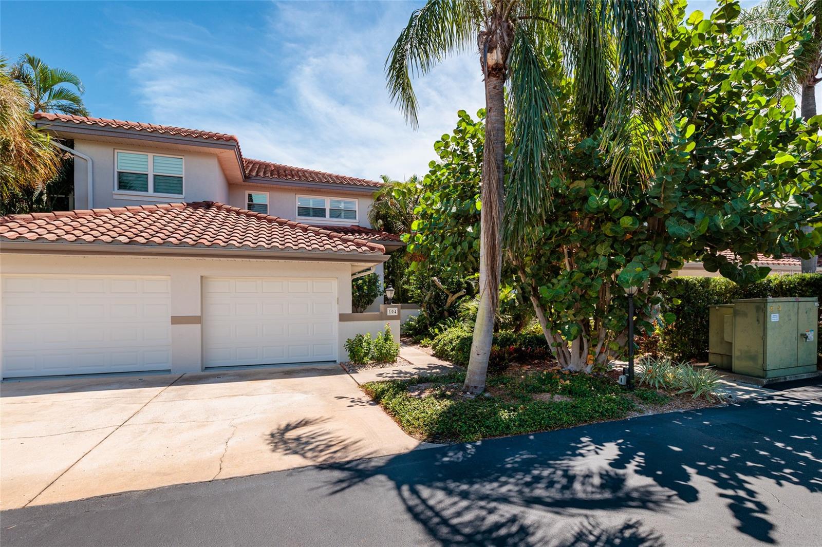 Private end-unit townhome with Mediterranean roofline and lush landscaping.