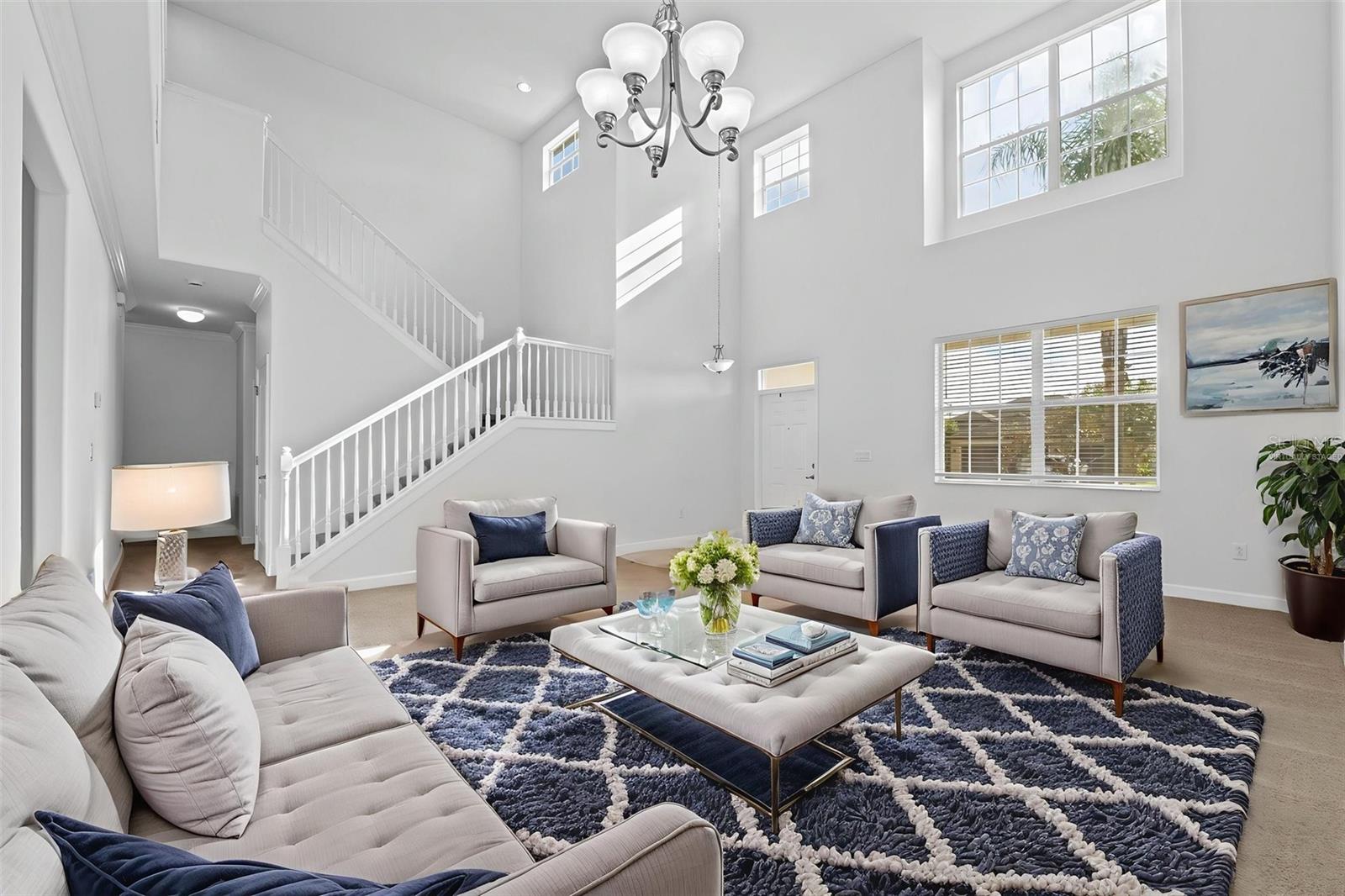 Virtually Staged Entryway Living Room and Dining Area with High Ceiling