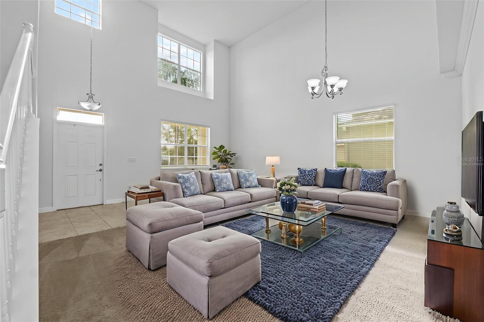 Virtually Staged Entryway Living Room and Dining Area with High Ceiling