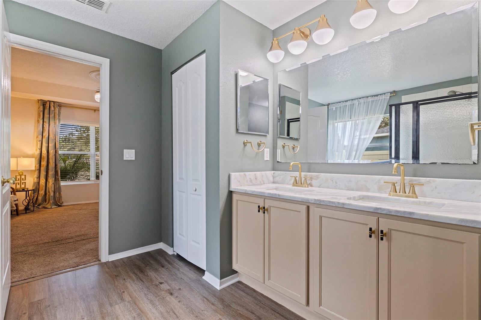 Primary bath with dual vanities and linen closet.